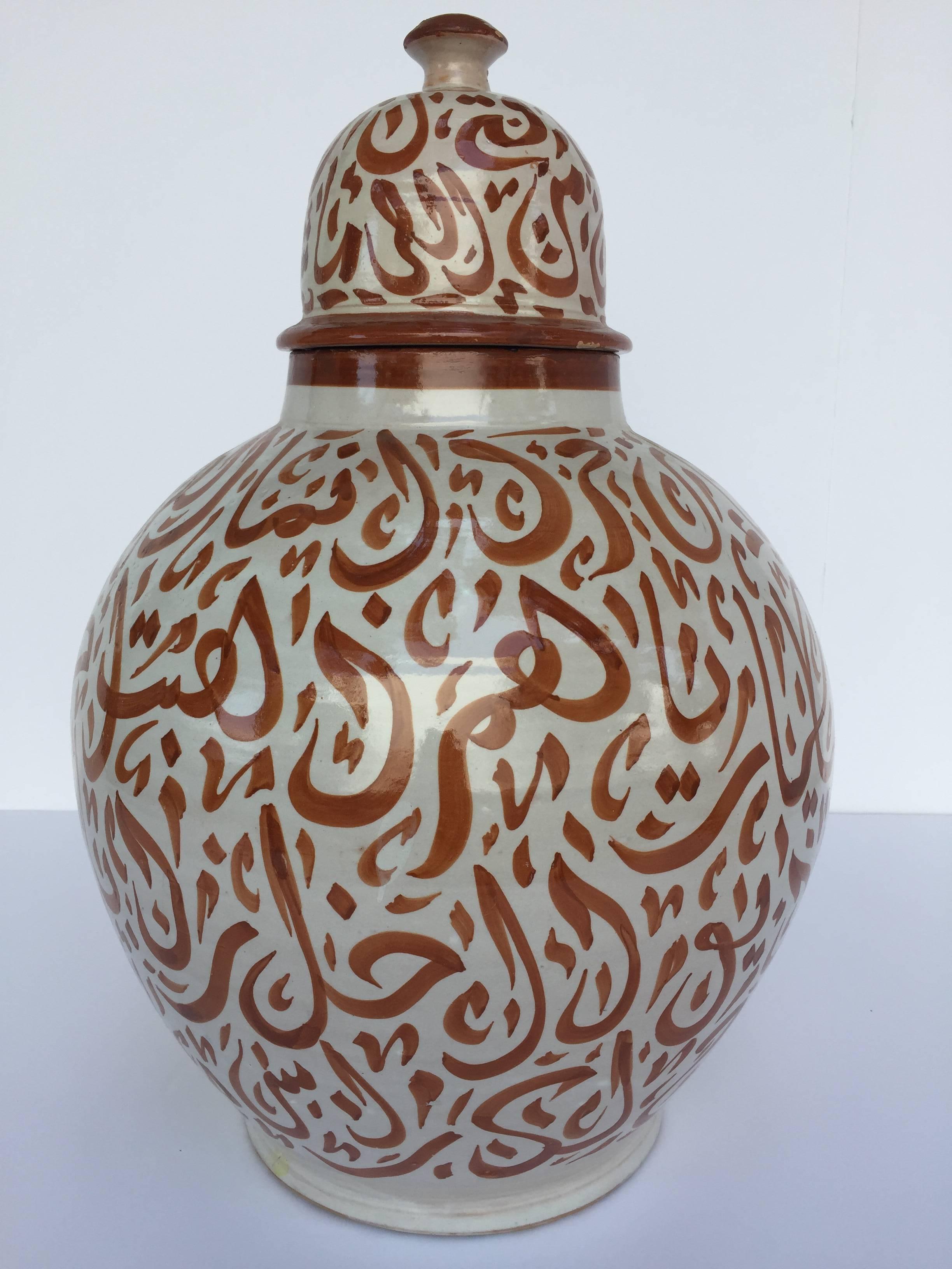 Large Moroccan glazed ceramic urn with lid from Fez. 
Moorish style ceramic handcrafted and hand-painted with Arabic calligraphy writing.
This kind of Art Writing looks calligraphic is called Lettrism, it is a form of art that uses letters that are