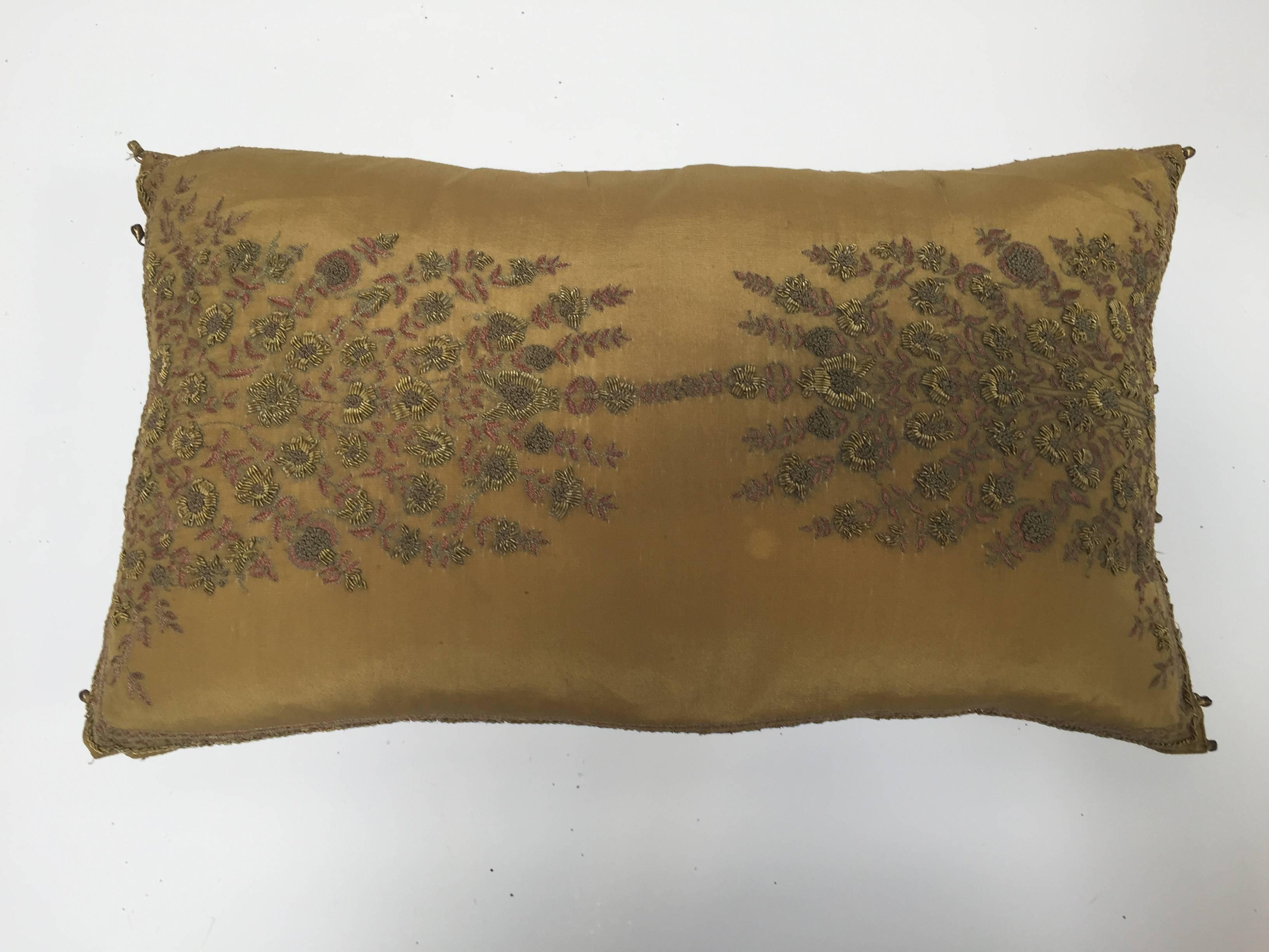 Throw pillow with raised gold metallic embroidery of vining flowers bronze silk.
By the J J Valaya 