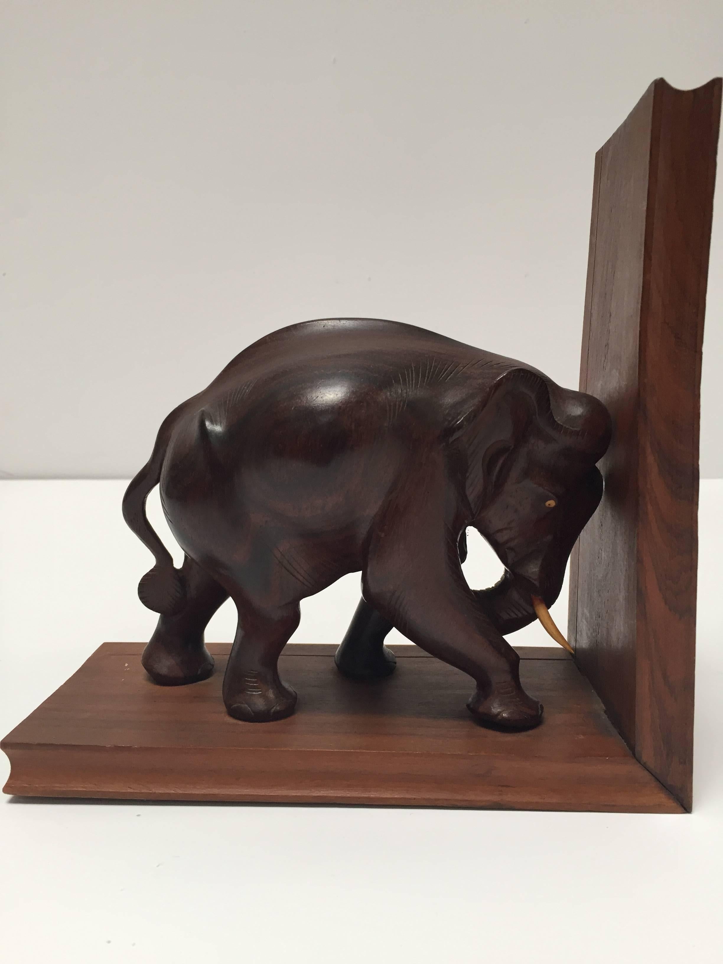 Nice pair of hand-carved wooden elephant bookends. 
One of the elephant is missing his tusks.
These are hand-carved and therefore not completely identical, 
circa 1950
Size for each piece is 8.25 in H. x 8.25 in W. x 4in D.