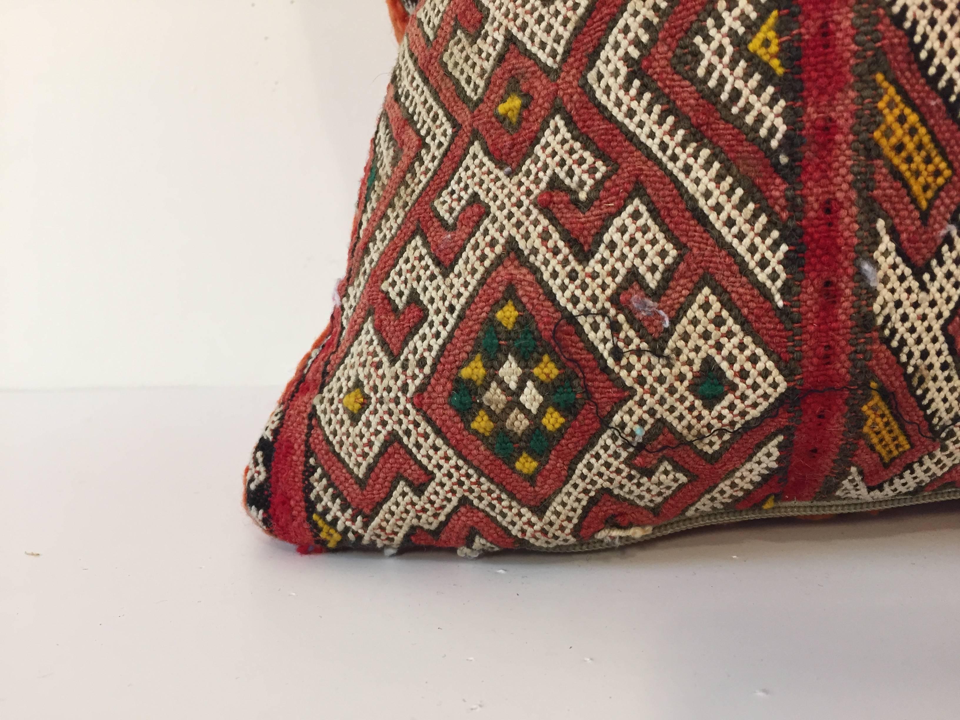 Moroccan Berber pillow red with geometric tribal designs.
Handwoven tribal throw pillow made from a vintage flat-weave rug. 
The front and the back are made from a different rug, front is more elaborate and back is burnt orange. 
Handwoven by