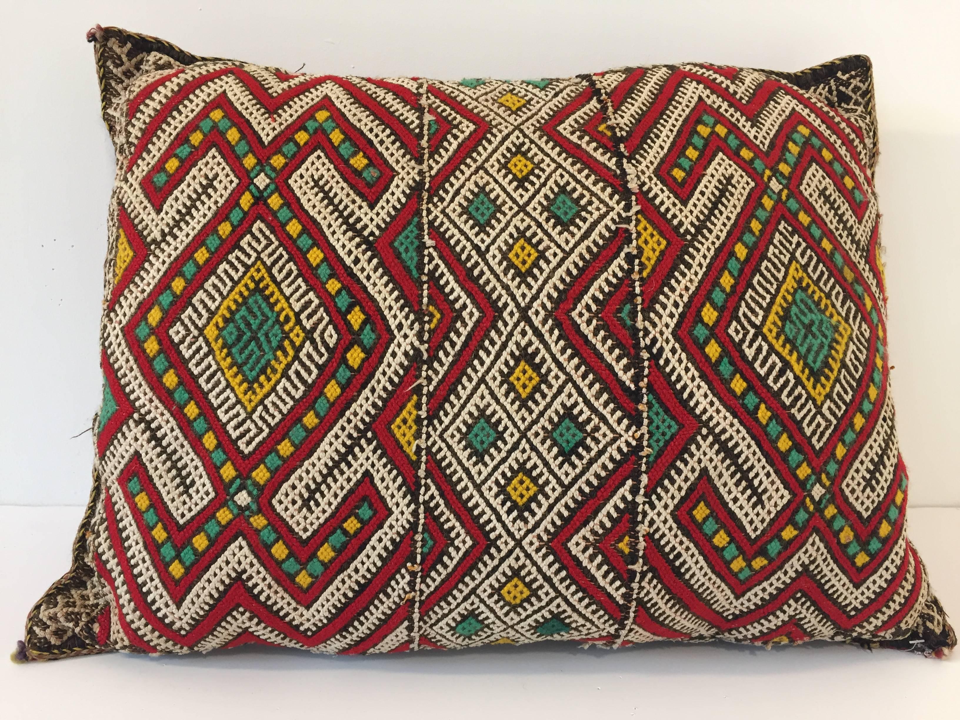Moroccan Berber pillow red with geometric tribal designs.
Handwoven tribal throw pillow made from a vintage flat-weave rug. 
The front and the back are made from a different rug, front is more elaborate and back is red with stripes. 
Handwoven by