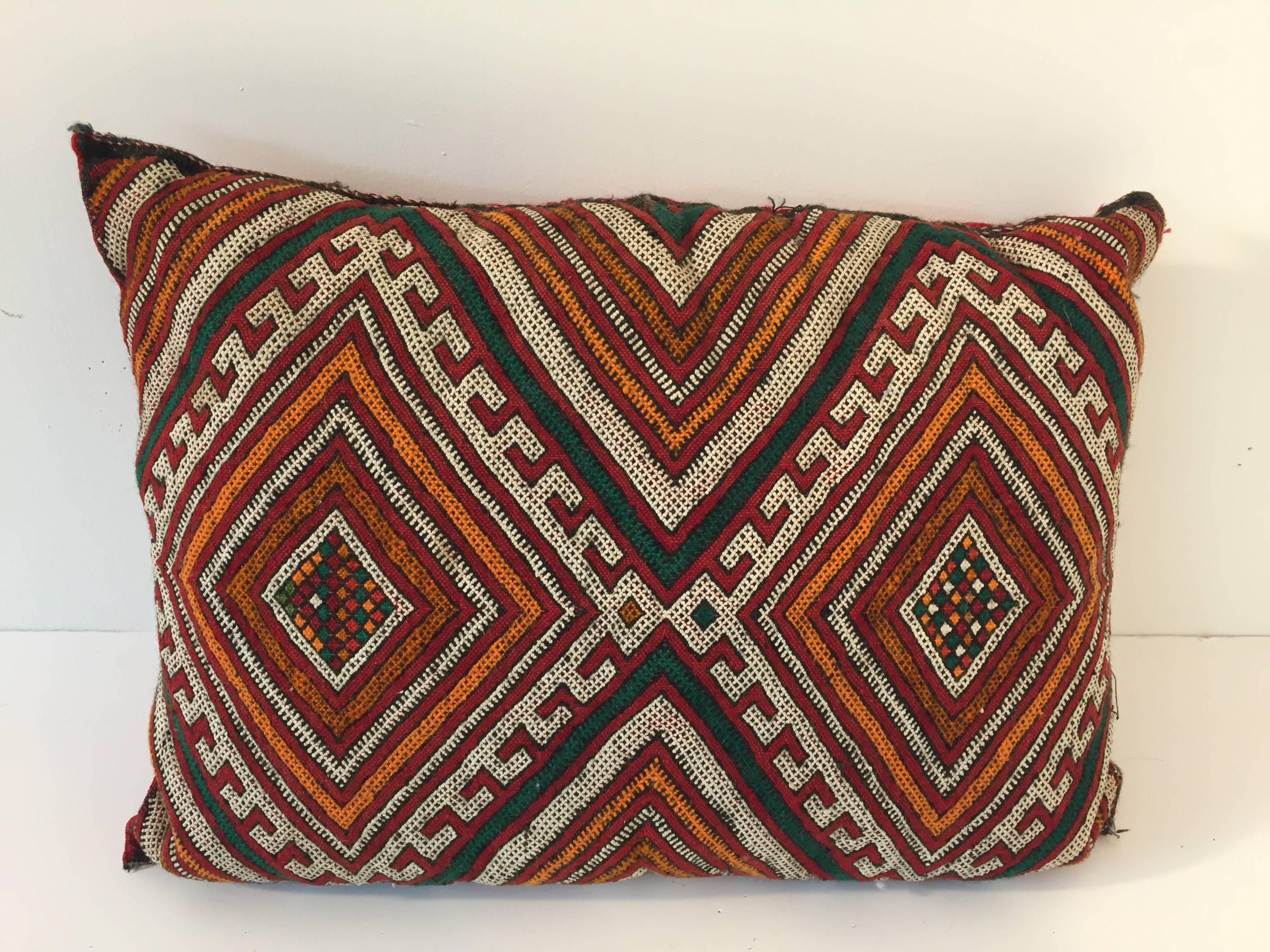 Moroccan Berber pillow red with geometric tribal designs.
Handwoven tribal throw pillow made from a vintage flat-weave rug.
The front and the back are made from a different rug, front is more elaborate and back is red with stripes.
Handwoven by