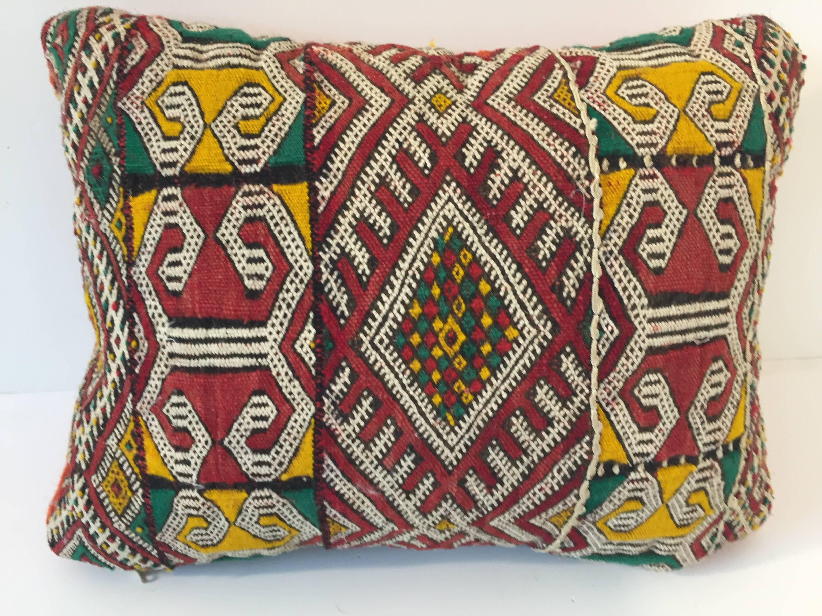 Moroccan Berber pillow red with geometric tribal designs.
Handwoven tribal throw pillow made from a vintage flat-weave rug. 
The front and the back are made from a different rug, front is more elaborate and back is burnt orange. 
Handwoven by