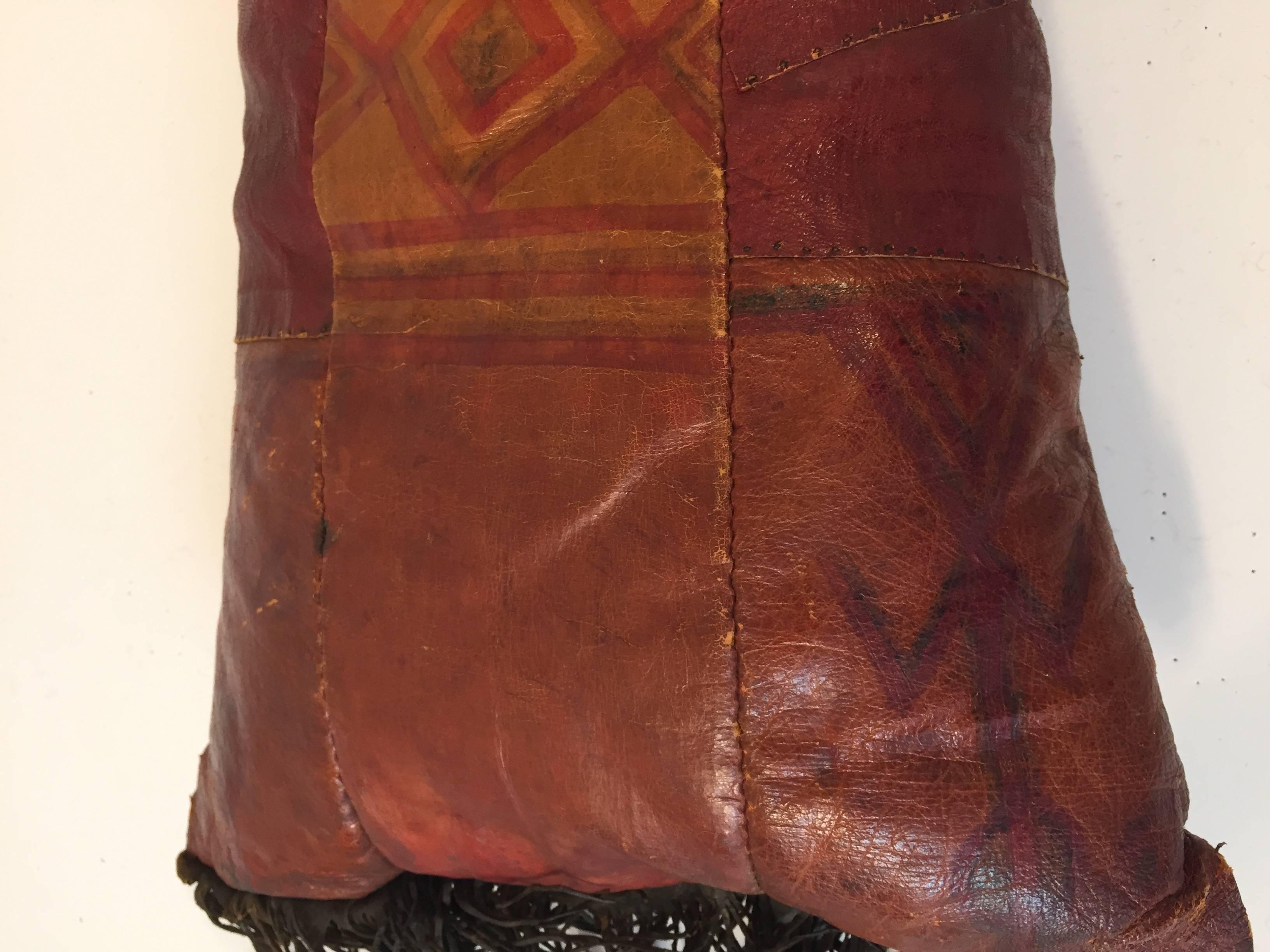 African Tuareg hand tooled leather pillow.
Great colors, hand-painted with tribal geometric design with long leather fringes on each side.
Handcrafted in Africa with pieces of leather sewn together and hand-painted, the back has a different