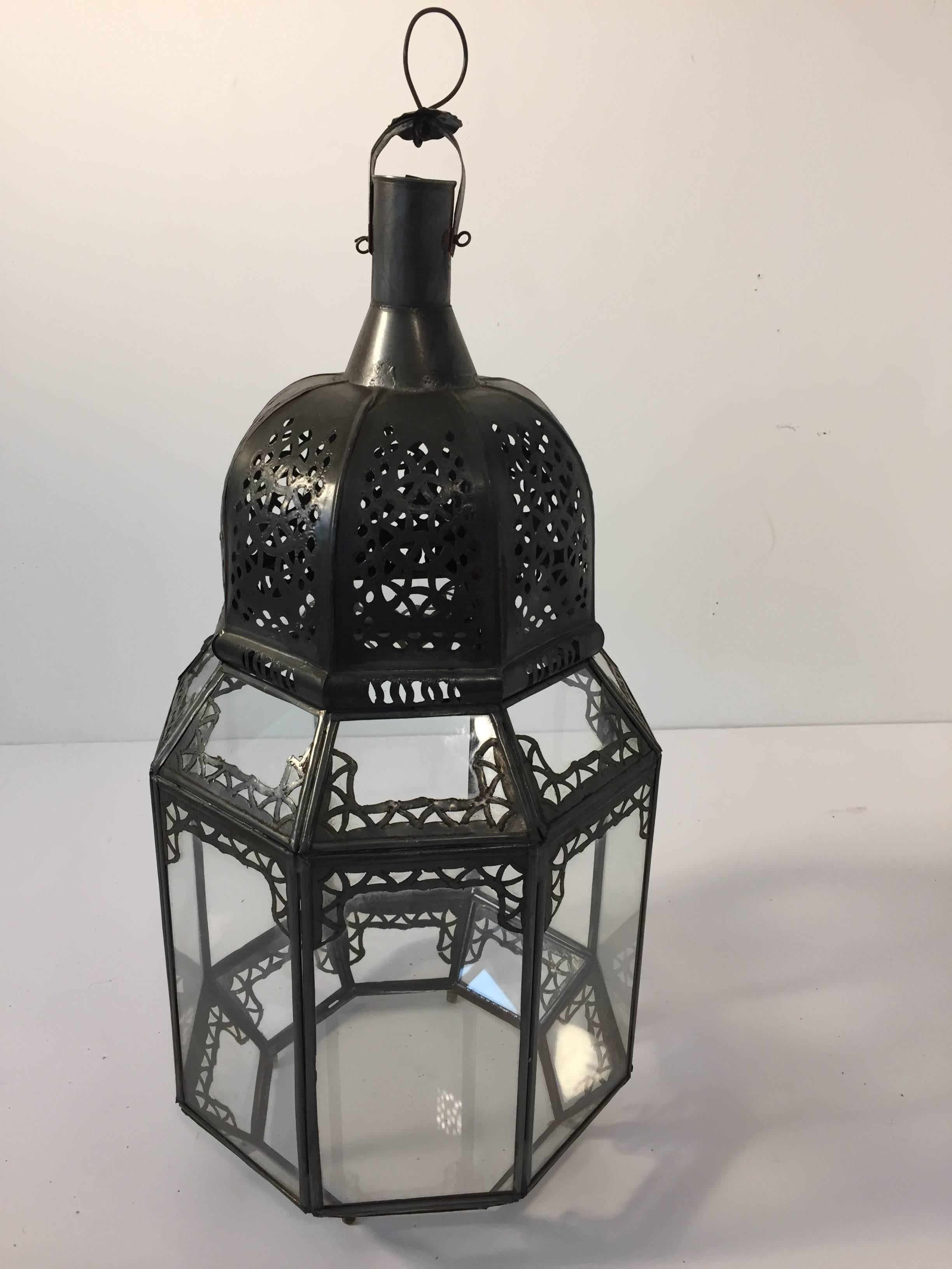 Vintage Moroccan Moorish clear glass lantern with intricate metal filigree.
Octagonal shape, delicately handcrafted by artisans in Morocco.
Bronze metal color finish.
Could be used with candle or rewired for electricity as a Moroccan pendant or wall