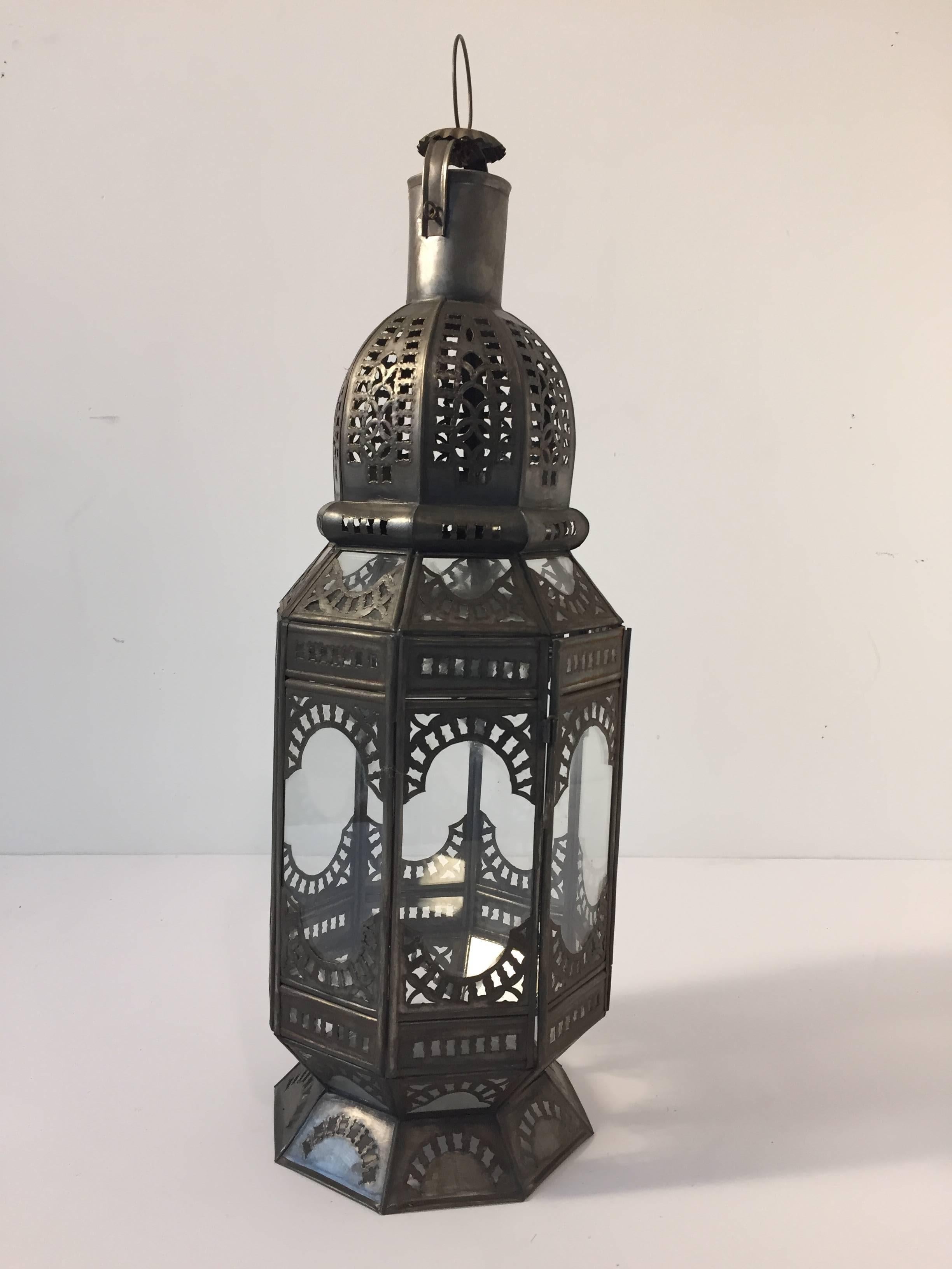 Octagonal shape handcrafted Moroccan clear glass lantern adorned with hand-carved metal filigree. 
Hurricane candle lamp metal with clear glass at the bottom with a small door to access the inside, could be used with pillar candles, could also be