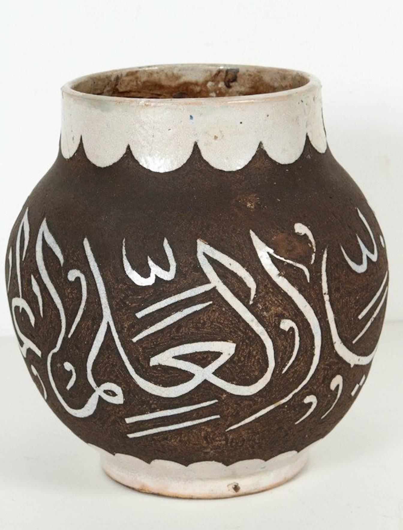 Decorative chiseled brown and ivory Moroccan ceramic vase from Fez hand-graved with ivory Arabic calligraphy.
This kind of Art Writing looks calligraphic is called Lettrism, it is a form of art that uses letters that are not supposed to mean