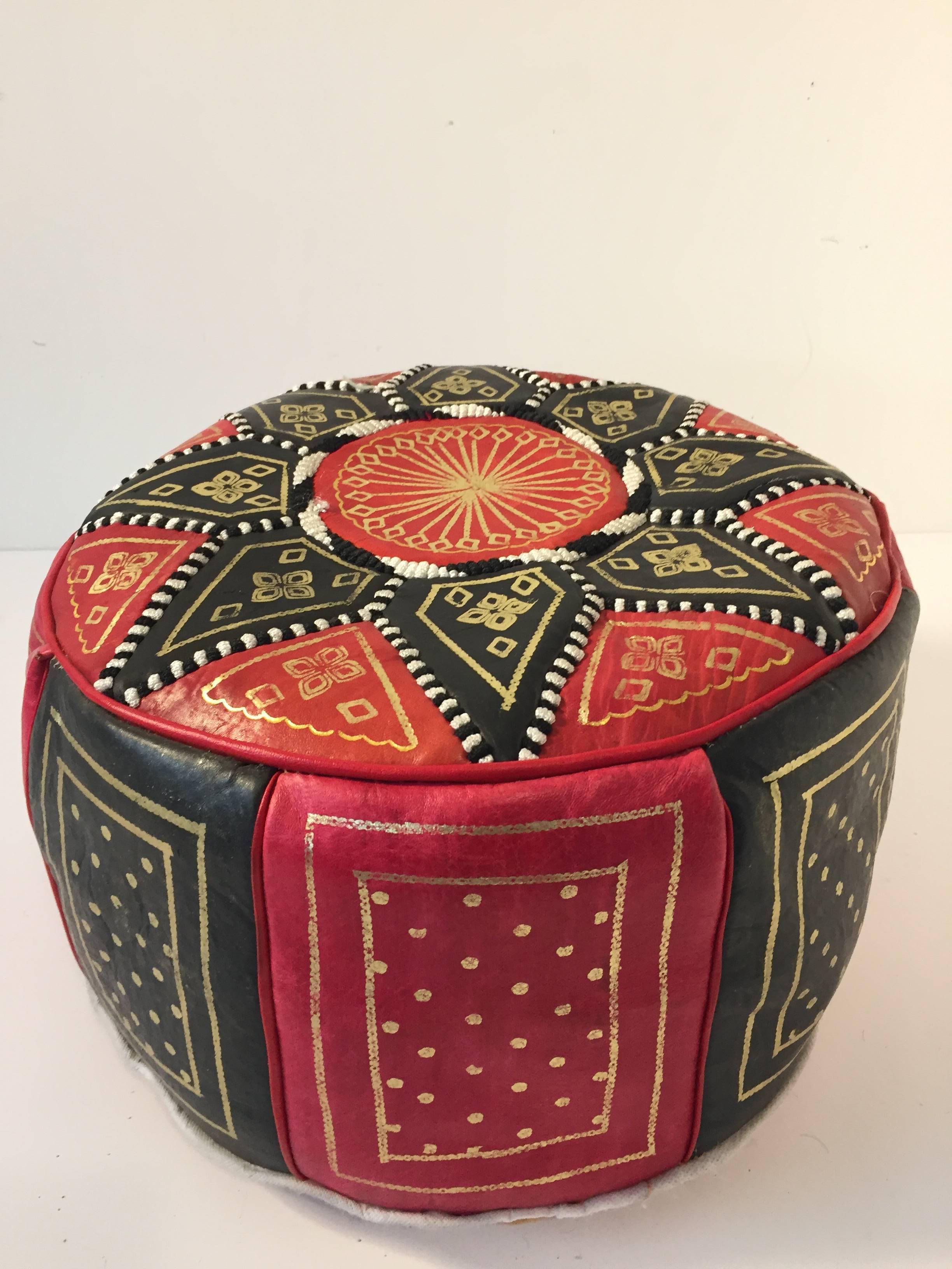 Moroccan red and black round pouf hand tooled and embroidered in Fez Morocco. 
Beautiful geometrical designs are hand-stitched and hand stamped on this Moroccan stool by expert Artisan. 
Use these round handcrafted poufs as ottoman, footstool or