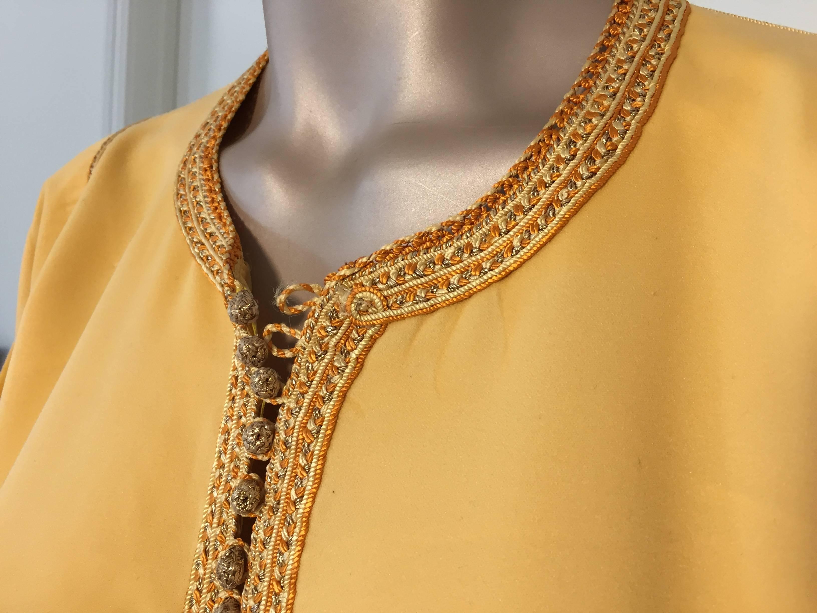 Elegant Moroccan caftan yellow gold color embroidered with gold trim,
circa 1960s.
This long Moorish maxi dress kaftan is embroidered and embellished with traditional designs in gold.
One of a kind custom evening Moroccan Middle Eastern gown.
The