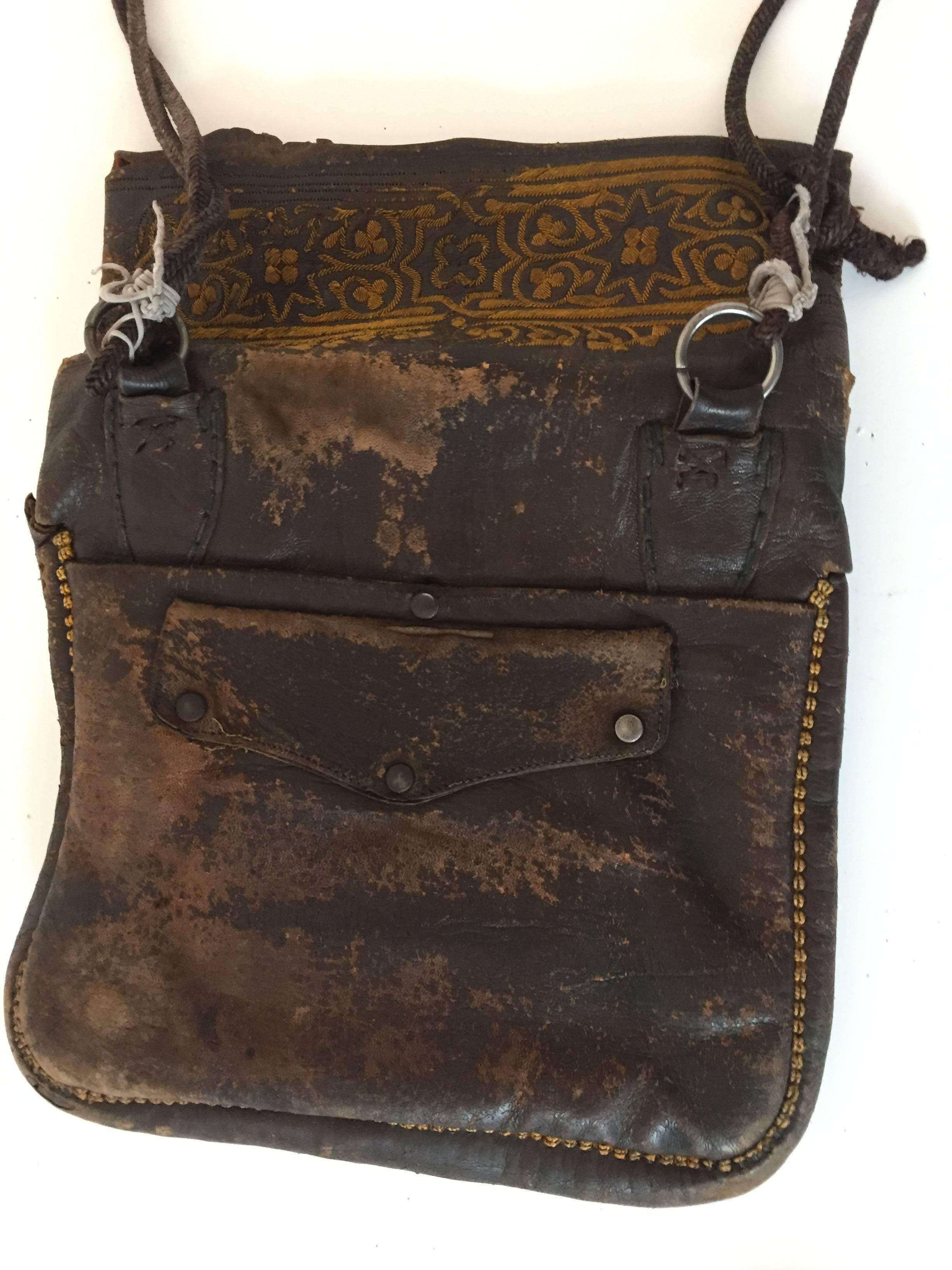 Old leather African Moroccan satchel bag with flap decorated with tribal embroideries.
Hand-tooled in Marrakech, this is an old antique man shoulder slim bag, merchants in Morocco when travelling used this bag under their coat to put their money