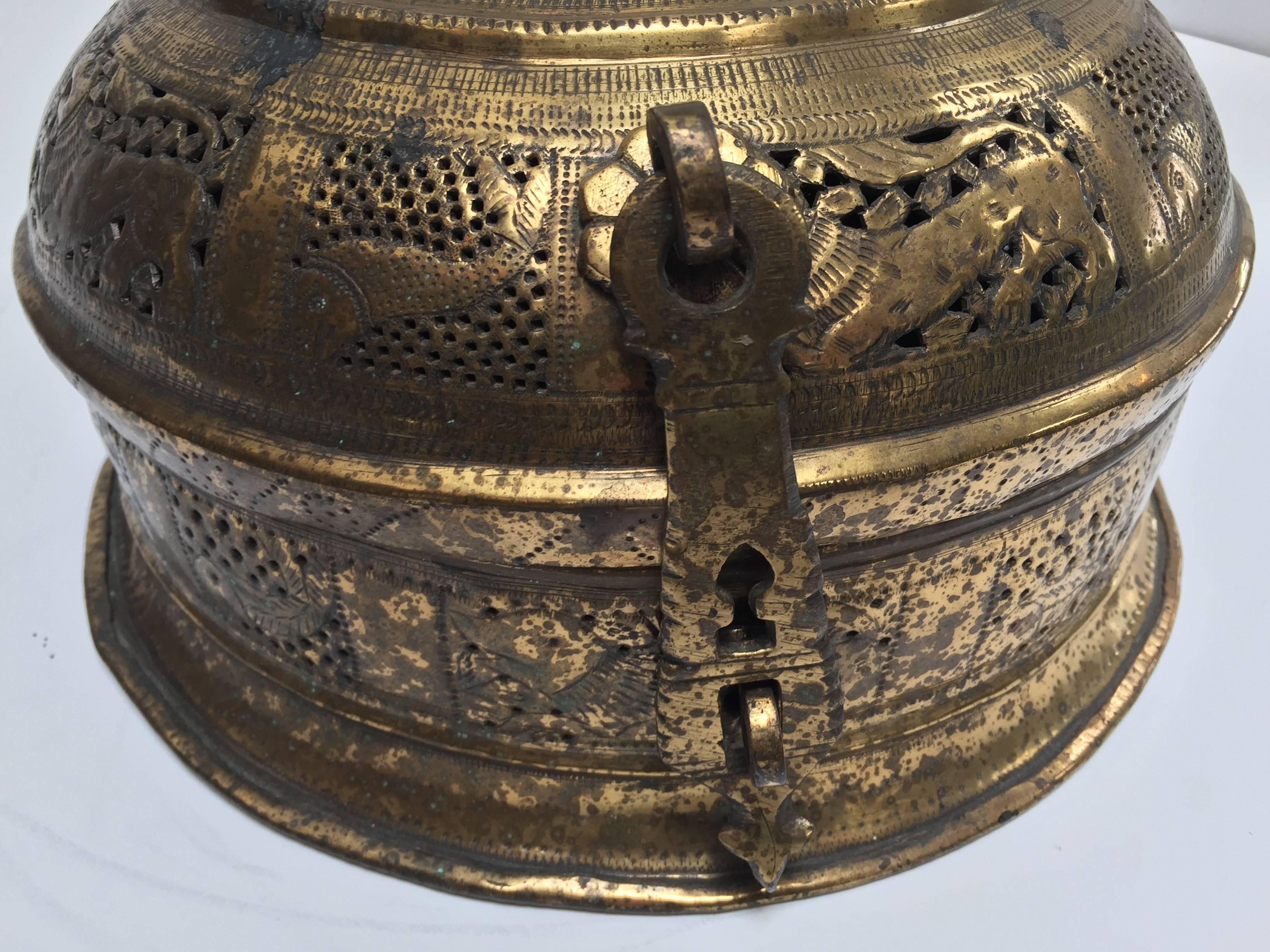 Handcrafted large decorative round bronze Anglo Indian box with with lid, latch and handle delicately and intricately hand-hammered with floral, fish and geometric repousse designs and has many holes.
Probably used as a tea caddy or cricket box