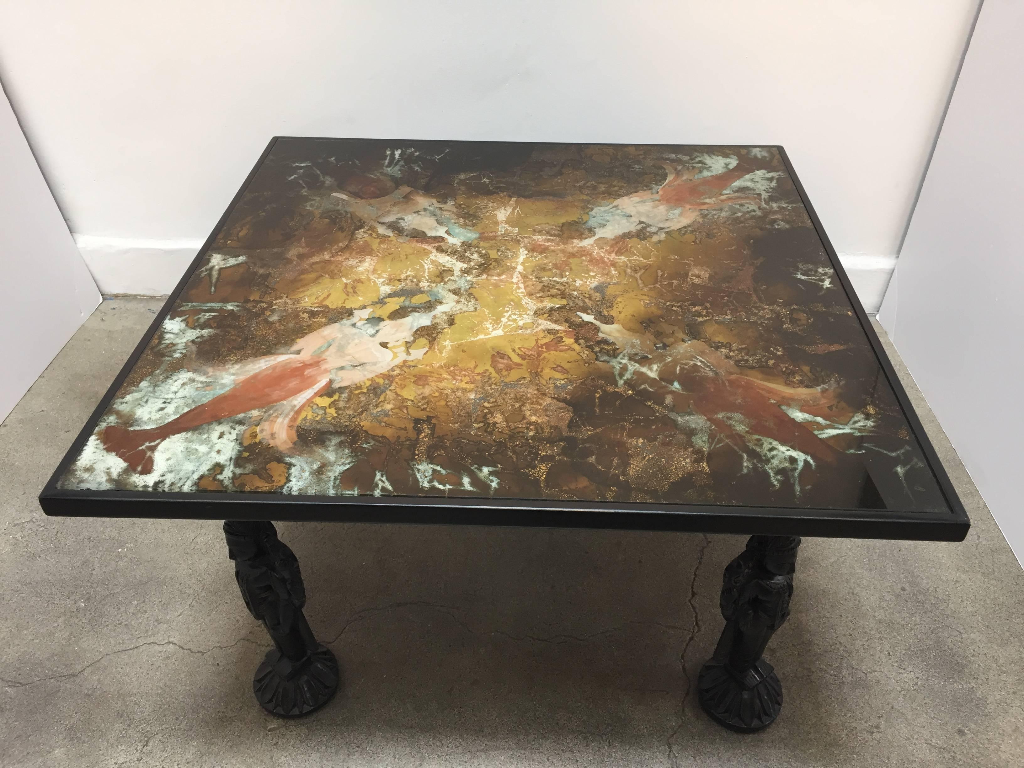 Asian inspire coffee table, with glass top painted in reverse with abstract designs, the four feet represent four Indian god Vishnu on lotus stand.
Black color wood and glass.
