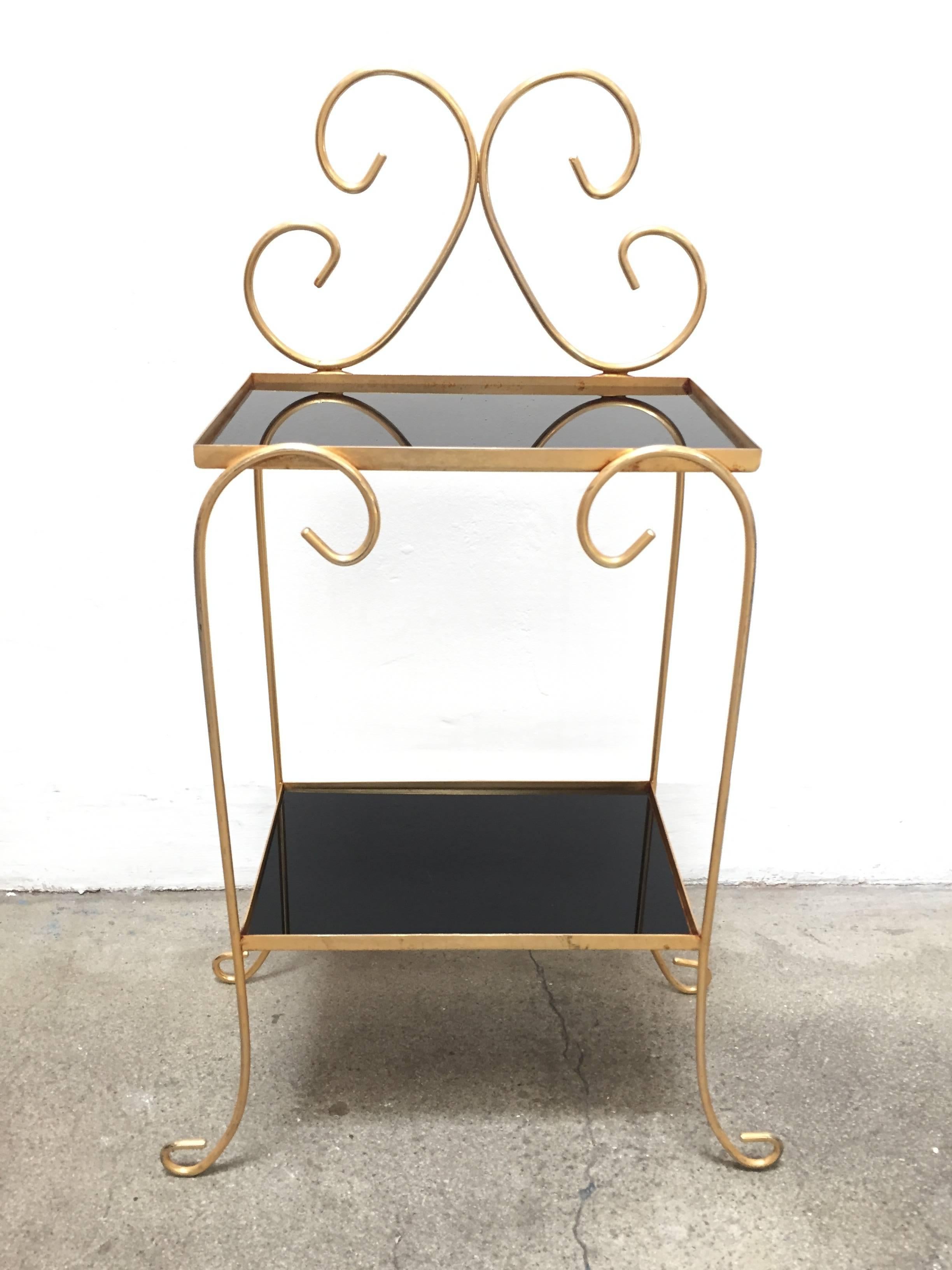 A fine French gilt iron side table with two-tier inset black mirrored glass.
Elegant gilt iron side table with curved iron legs and top decorative iron scrolls.
Maison Jansen style made in France.
Small side table.
Measure: Total height is 30.5