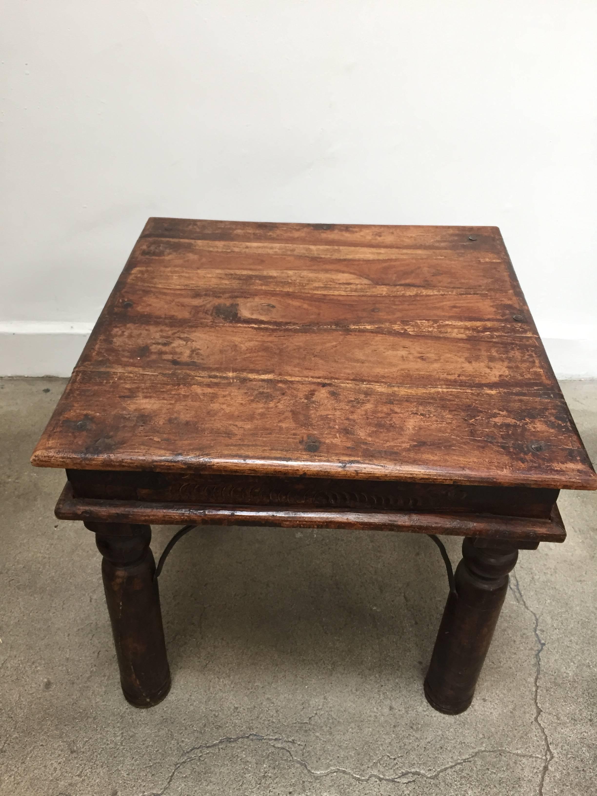 Vintage handcrafted teakwood rectangular side table.
Large rounded nail heads and metal accents support, very nicely carved legs.
Classic old India bajot table with beautiful signs of age and use. 
Sides and corners are reinforced with metal iron