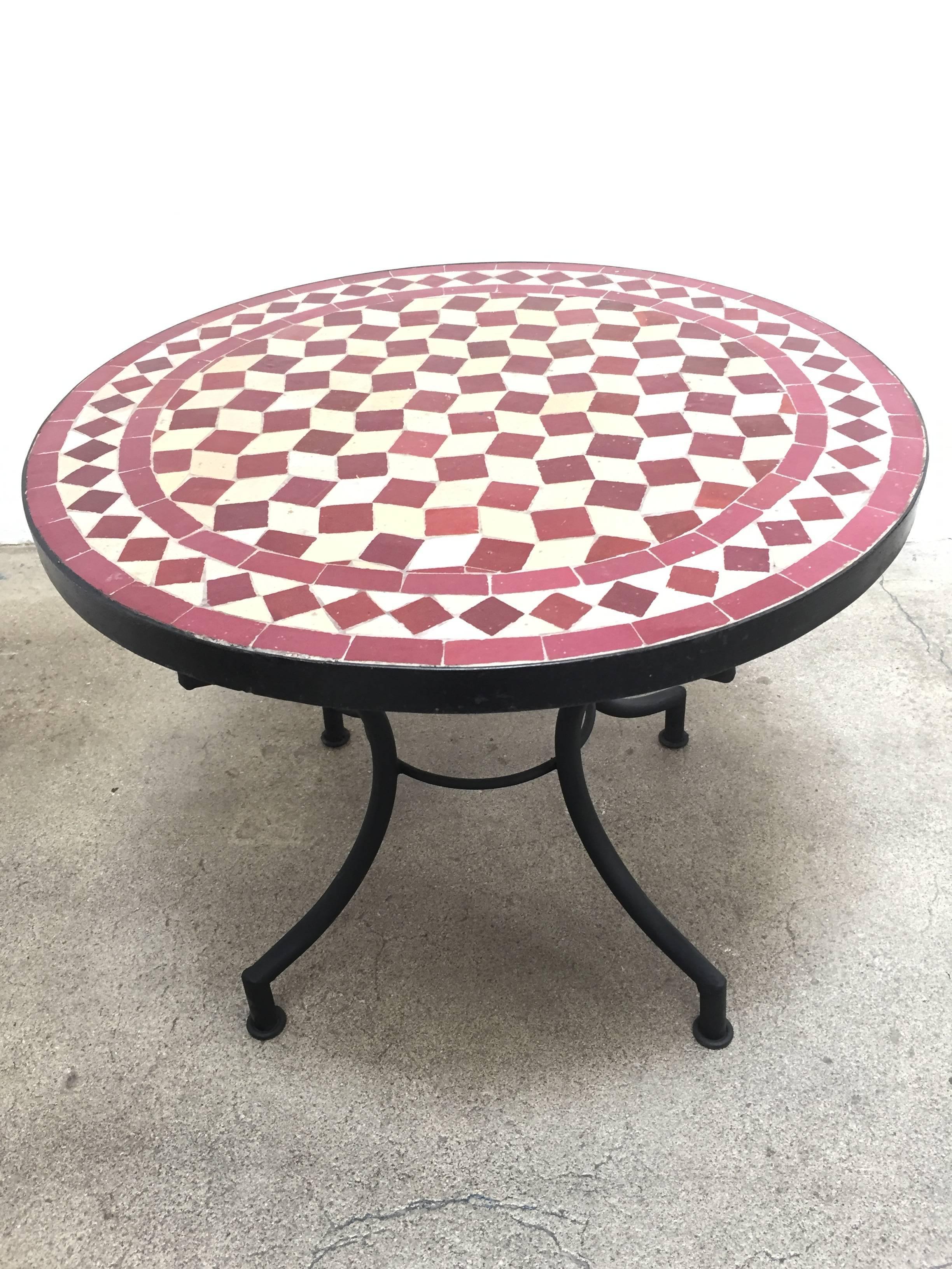 Moroccan mosaic tile table on low iron base.
Handmade by expert artisans in Fez, Morocco using reclaimed old glazed tiles inlaid in concrete and making beautiful geometrical designs, colors are burgundy and tan.
These tables could be used indoor or