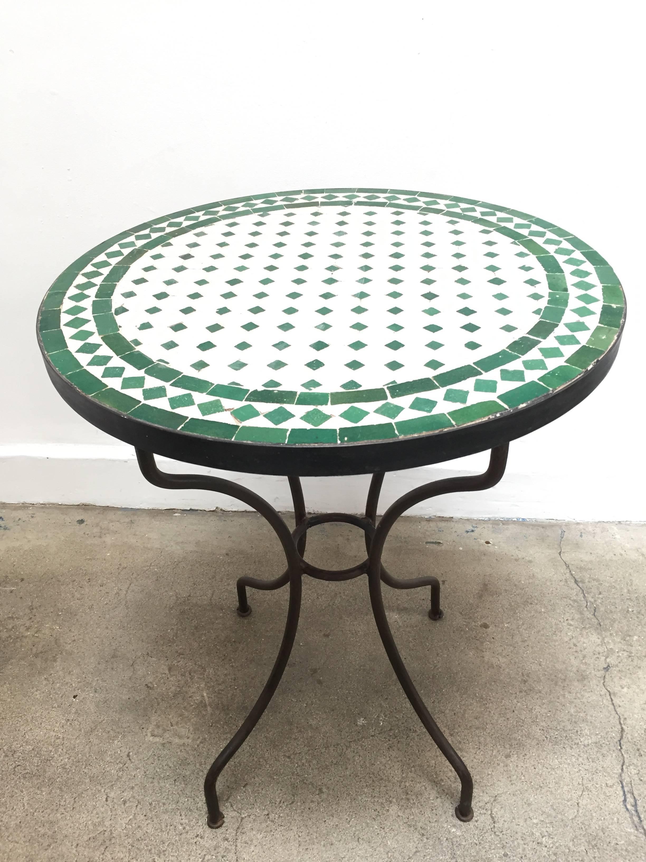 Moroccan mosaic tile bistro table on iron base. 
Handmade by expert artisans in Fez, Morocco using reclaimed old glazed tiles inlaid in concrete using reclaimed old glazed tiles and making beautiful geometrical designs, colors are green and white,