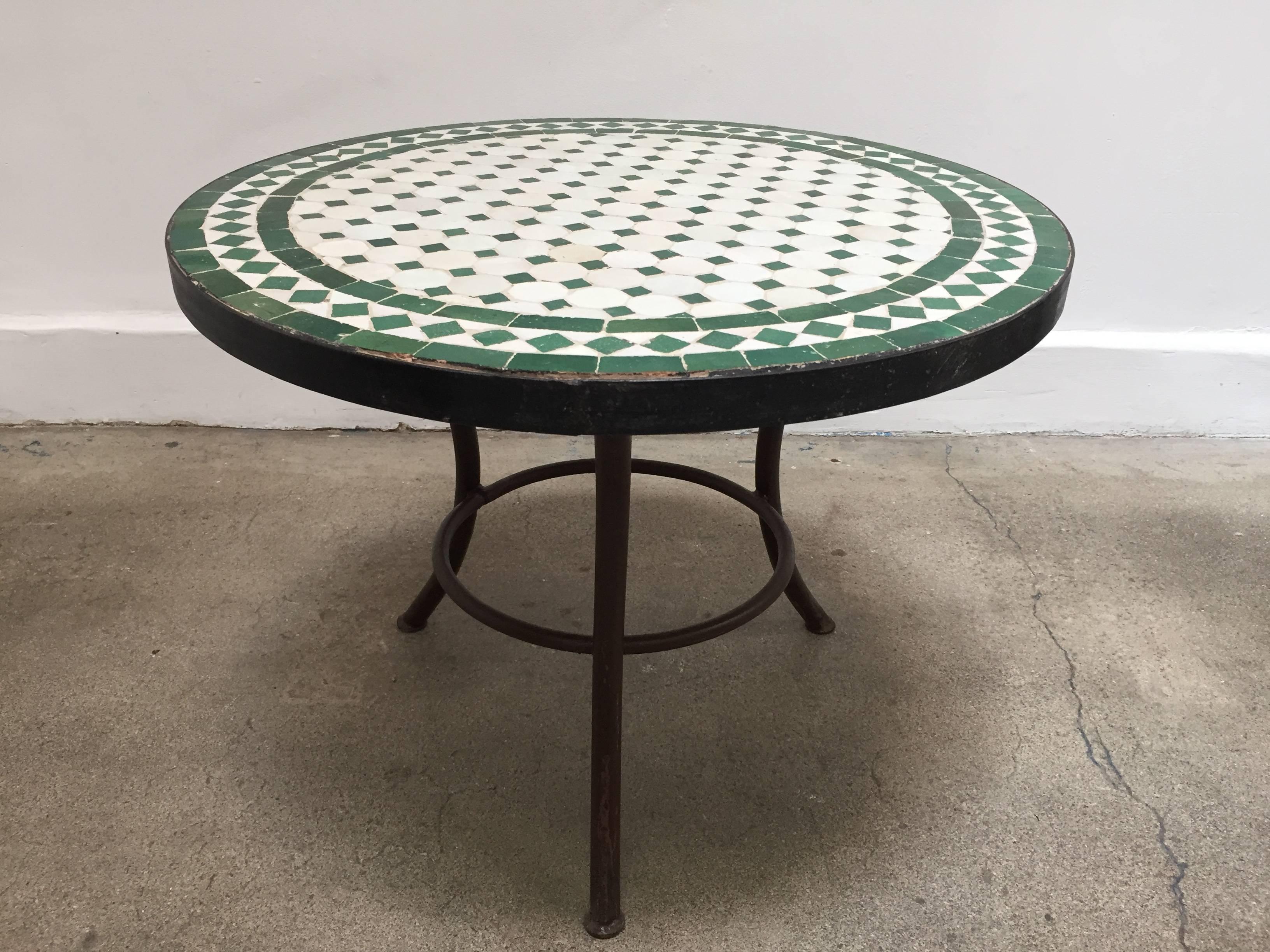 Moroccan mosaic tile table on low iron base. 
Handmade by expert artisans in Fez, Morocco using reclaimed old glazed tiles inlaid in concrete and making beautiful geometrical designs, colors are green and white. 
These tables could be used indoor or