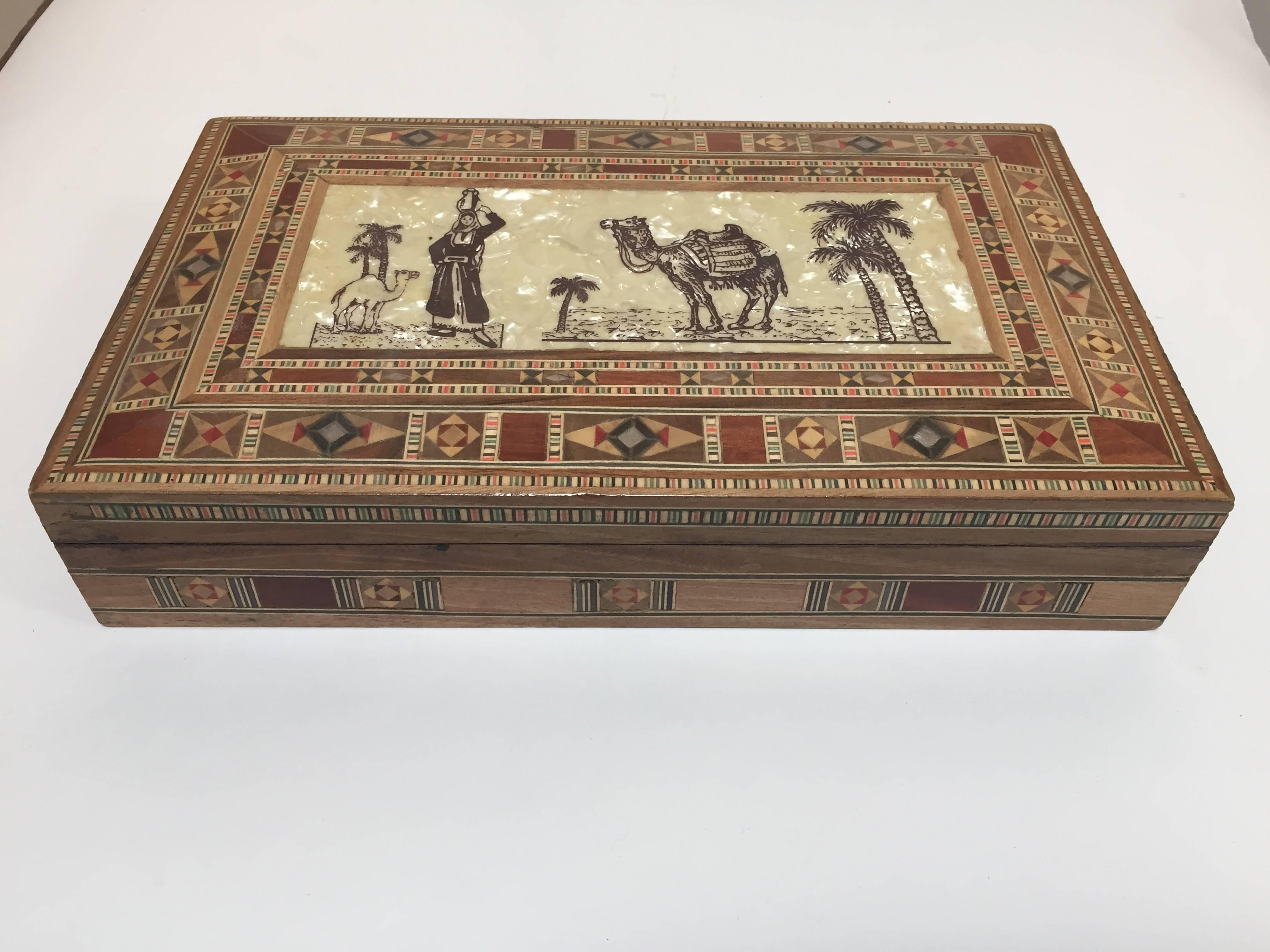 Exquisite handcrafted Middle Eastern Syrian walnut wood jewelry box intricately inlaid with Moorish motif designs which have been painstakingly inlaid mother-of-pearl and marquetry in different fruitwoods and decorated with a desert scenes with a