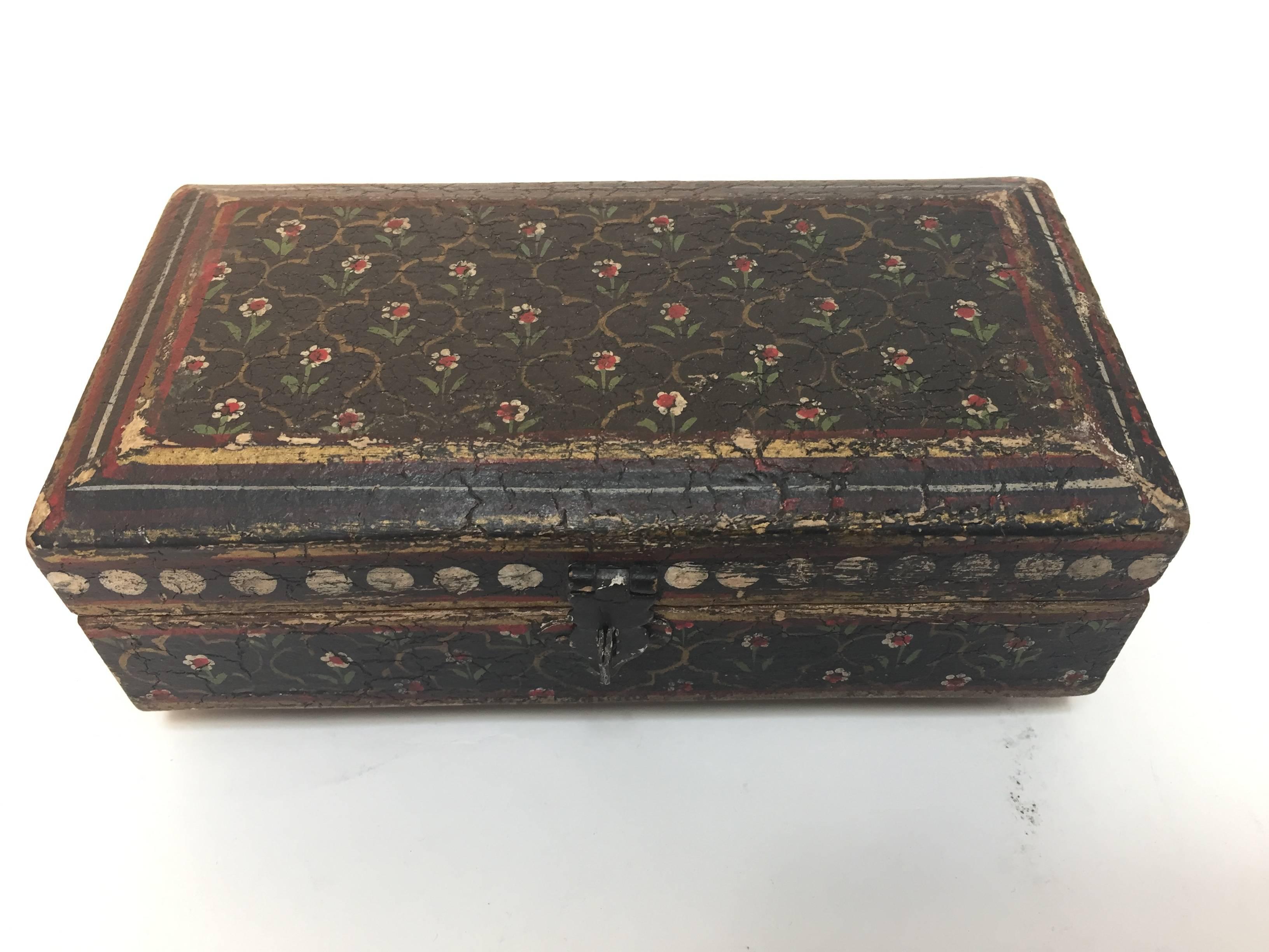 Hand-painted Rajhastani decorative footed tea box.
Hand-painted rectangular shape wood with hinged lid and decorated with floral designs on black outside and gold on ivory inside.