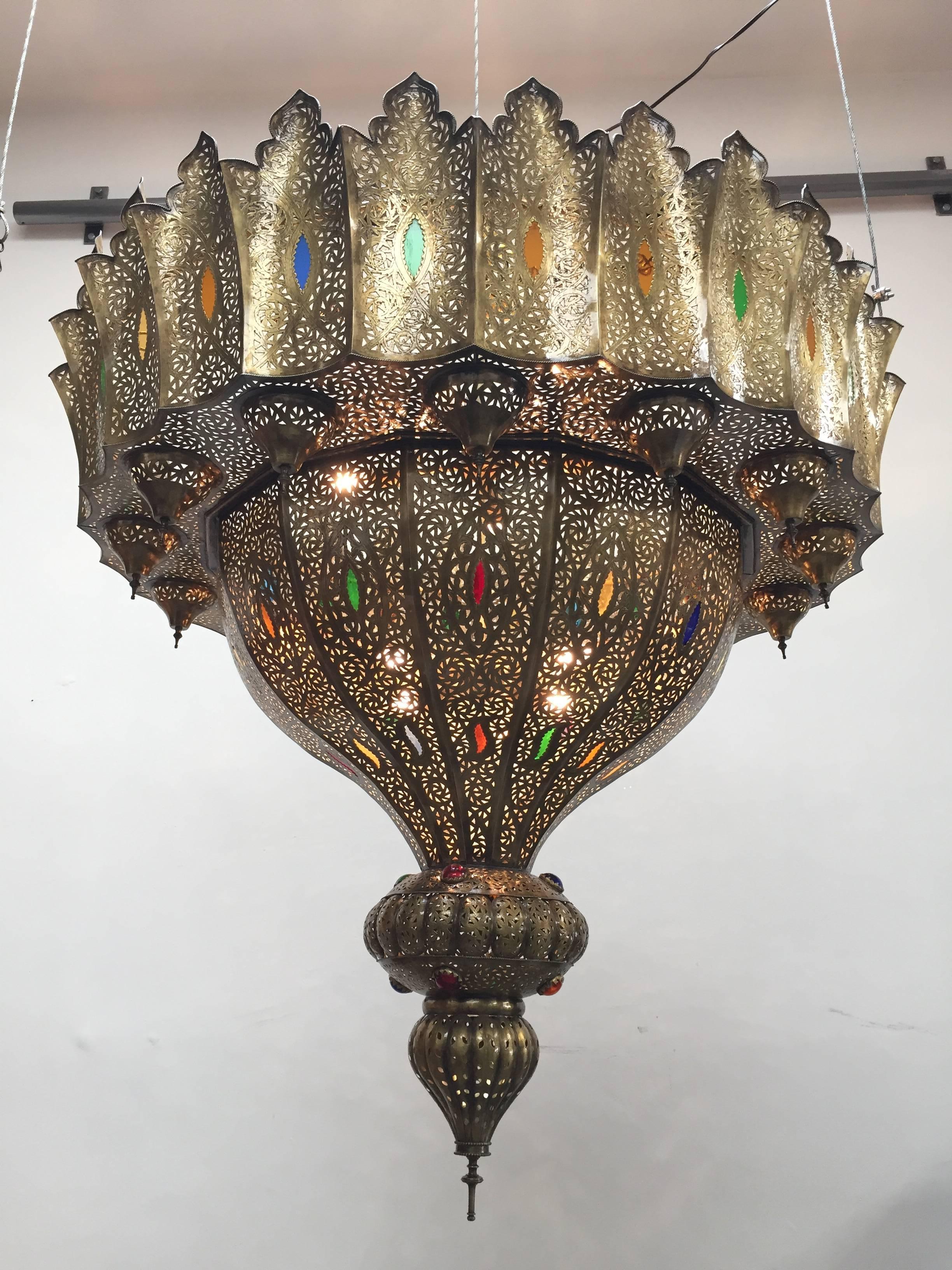 Oversize brass Moroccan Moorish chandelier in the style of Alberto Pinto Moorish design.
Delicately handcrafted in brass repousse and chiseled with fine filigree designs and handblown glass.
Oversized exquisite hand pierced brass Moroccan light