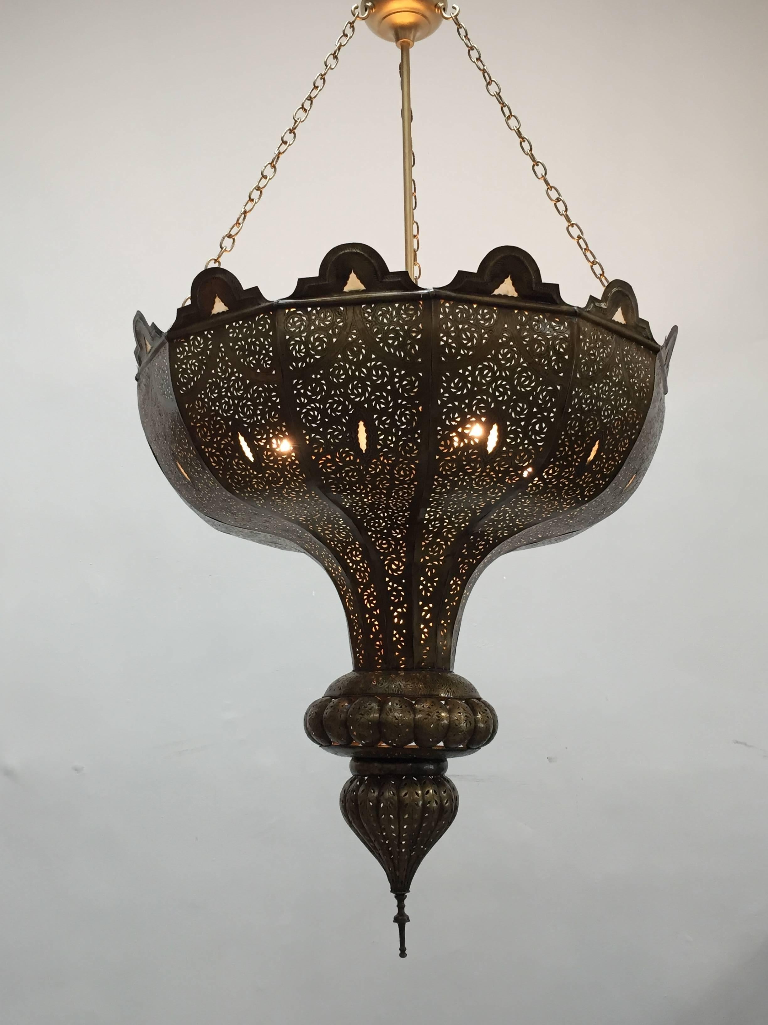 Oversize exquisite Moorish brass filigree pierced brass Moroccan chandelier in Alberto Pinto style. 
This exquisite Moroccan Alhambra light fixture is delicately handcrafted from brass repousse and chiseled with Fine filigree designs, adorned with