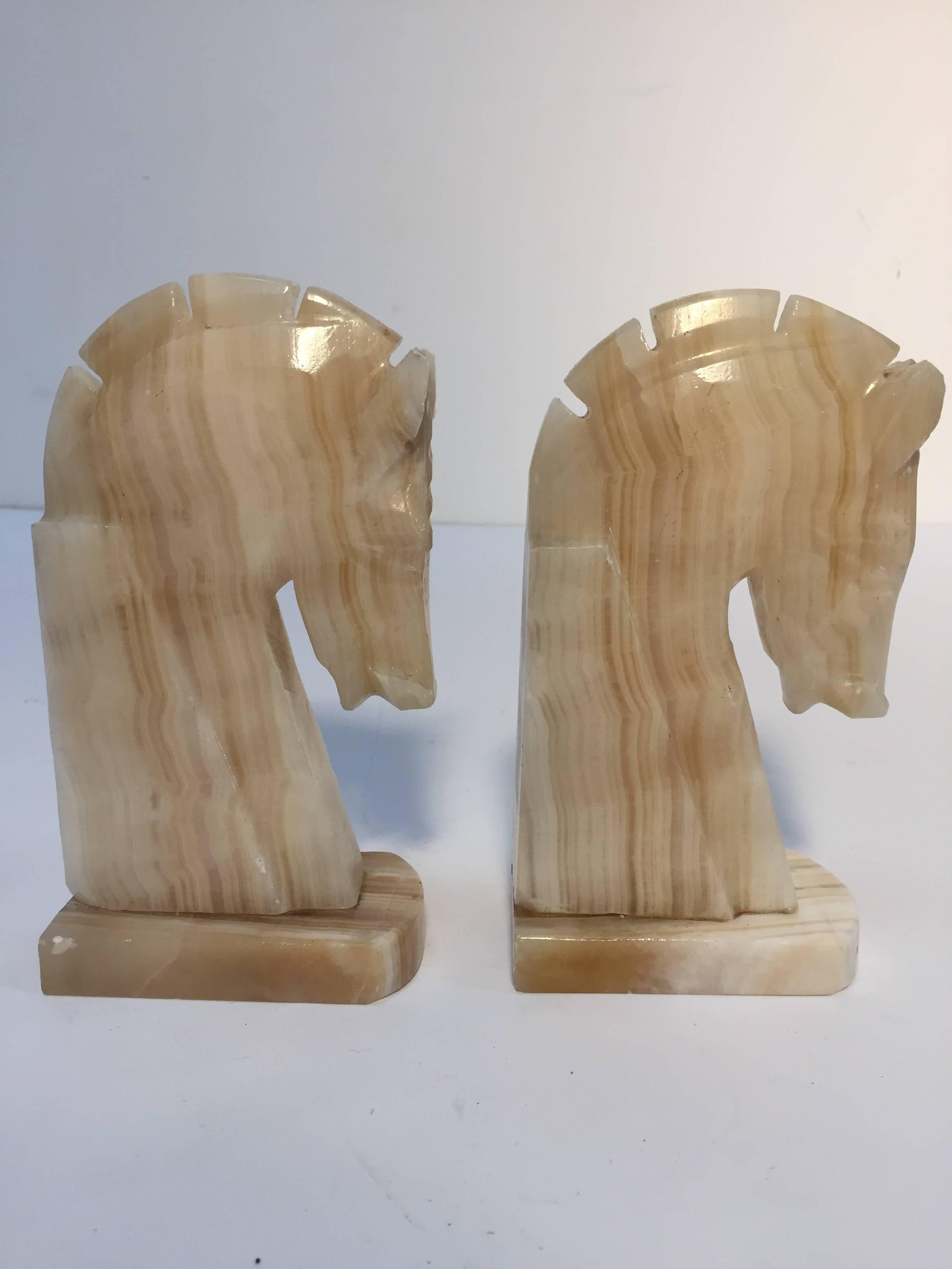 Pair of Art Deco style stylized horses head bookends. 
Vintage set of bookends, hand-carved in onyx in a shade of ivory and browns. 
Hermes style horses, great modern design. 
Measures: Each horse head measure 7.5