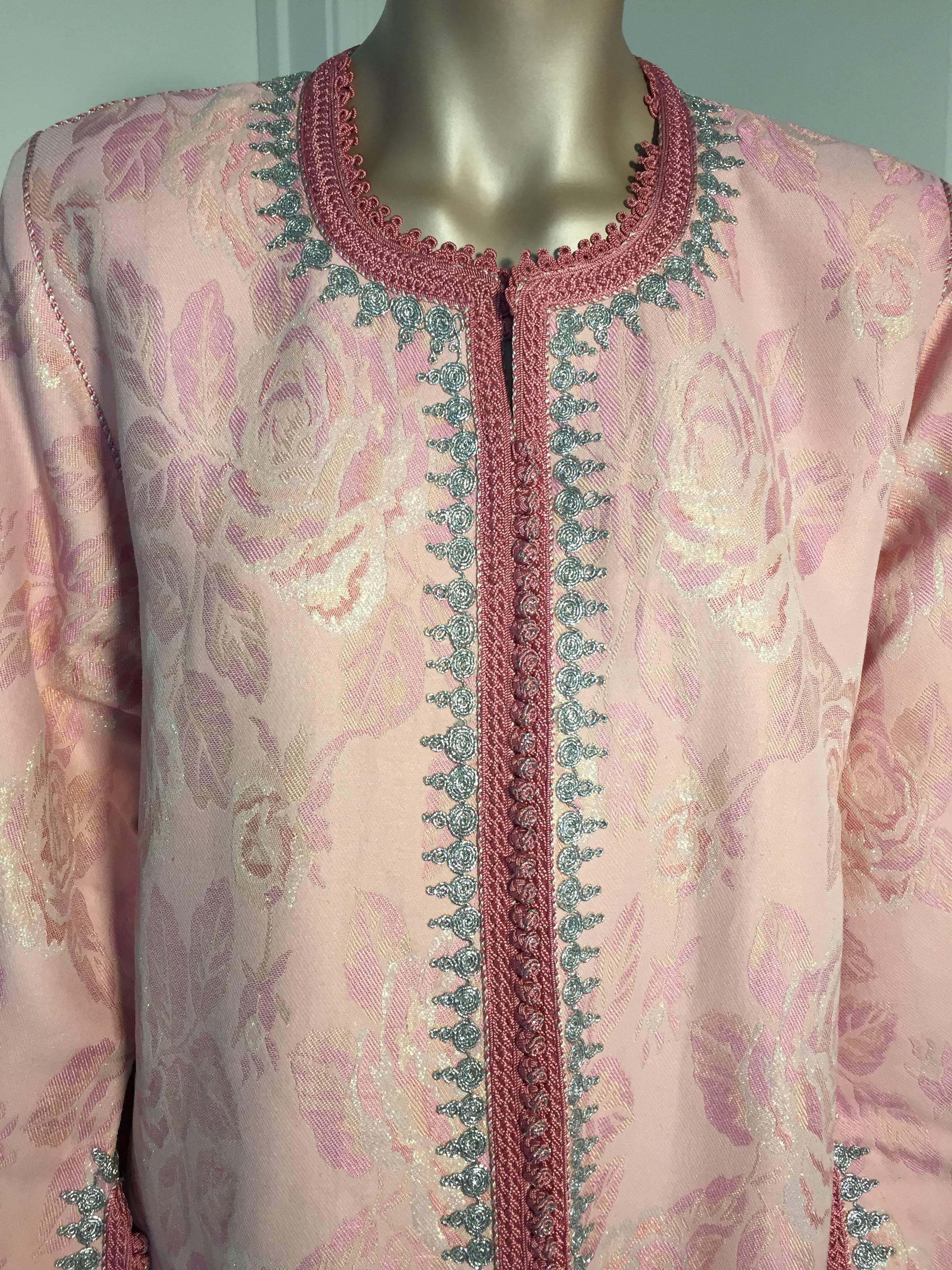 Elegant Moroccan exotic brocade caftan in metallic pink and silver,
circa 1970s.
This long maxi gown dress kaftan is embroidered and embellished entirely by hand with braided buttons and loops at the neck and on each sleeves, the narrow silken braid