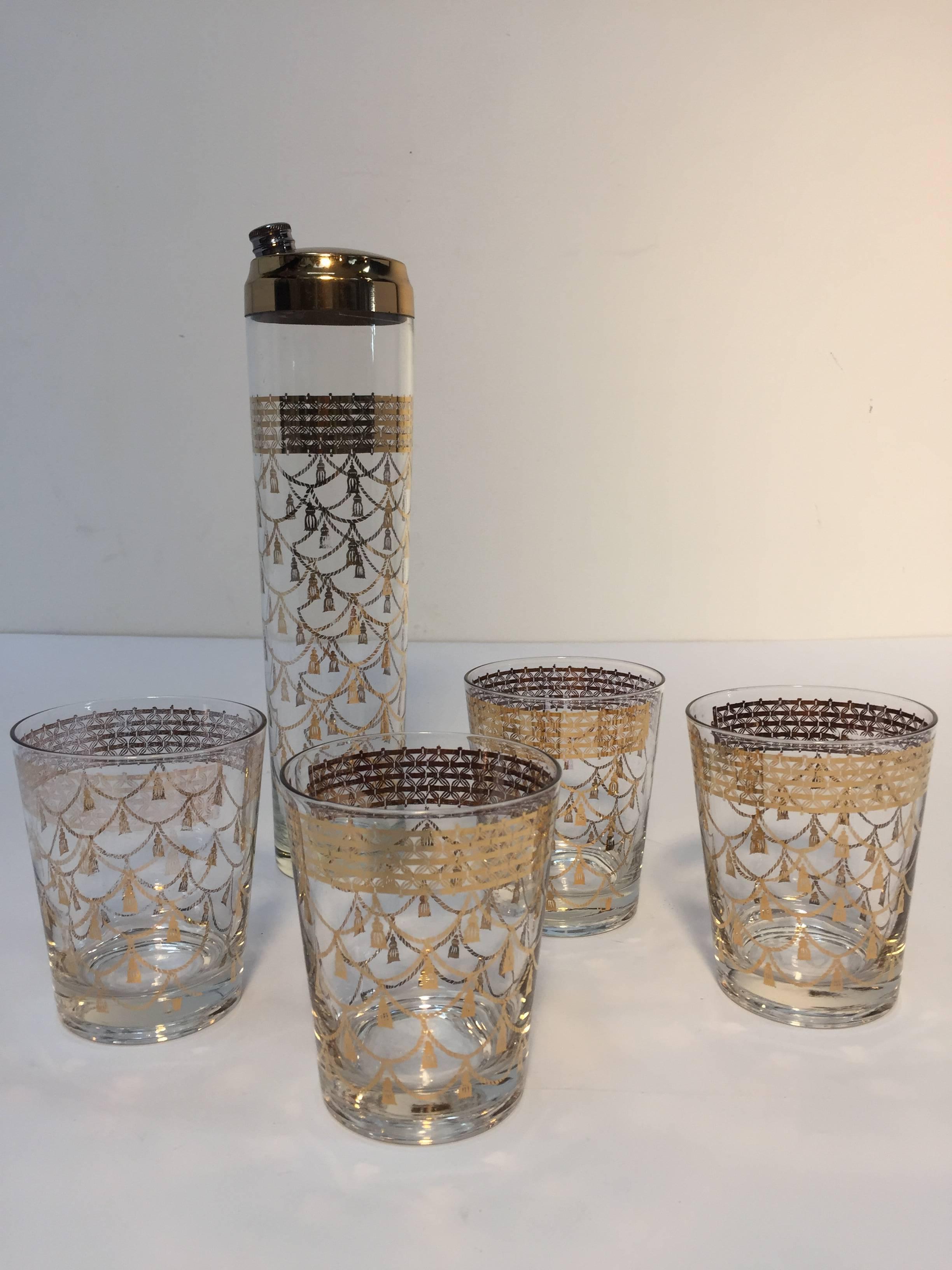 Hollywood regency elegant vintage Culver cocktail set of mid-century barware glasses with 22-karat gold leaf design.
Includes four large cocktail glasses and one cocktail shaker with brass piece top. 
Moroccan themed design with gold tassels, and