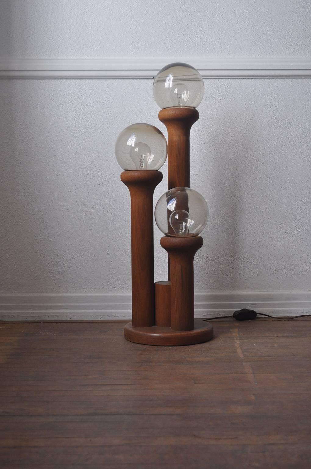 1970s solid walnut lamp with sculpted details and glass globe shades. Glass shades can be removed.