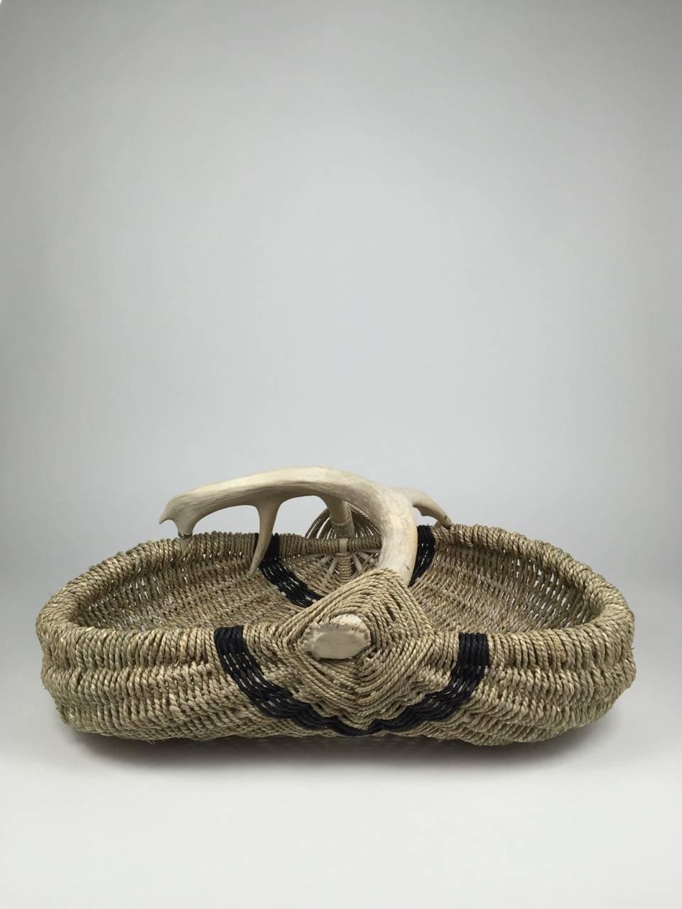 This large-scale handmade, custom basket, made with shed white tail deer antler, reed, and Oriental sea grass, is made by Los Angeles based artist and designer, Dax Savage. Having learned the art of antler basket weaving from his mother, Savages’