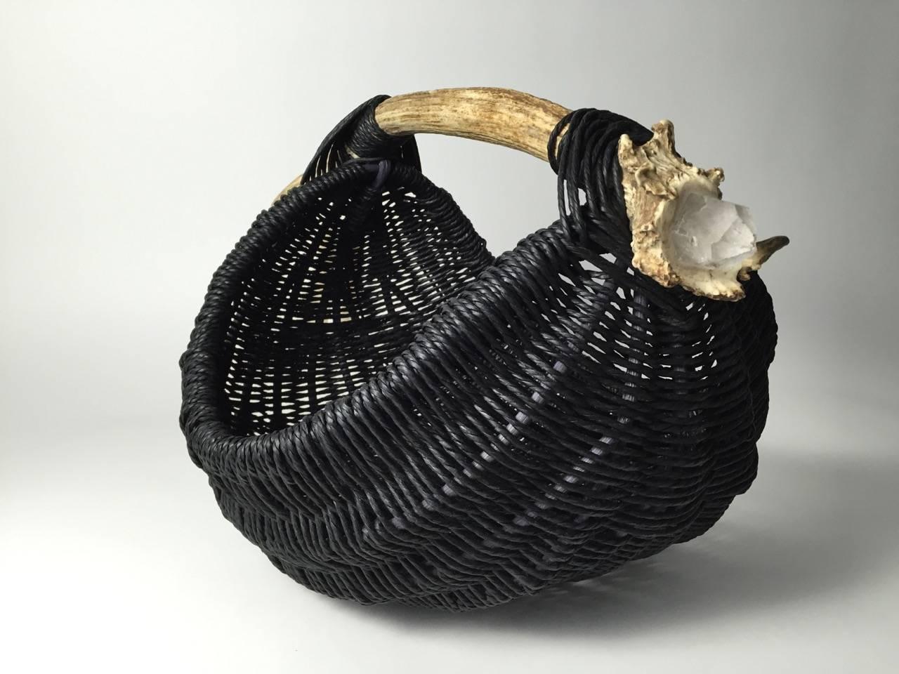 This handmade, custom basket is made with shed white tail deer antler, embedded with a raw quartz crystal, reed, black Danish wood pulp rope, leather and horse hair tassel by Los Angeles based artist and designer, Dax Savage. Having learned the art
