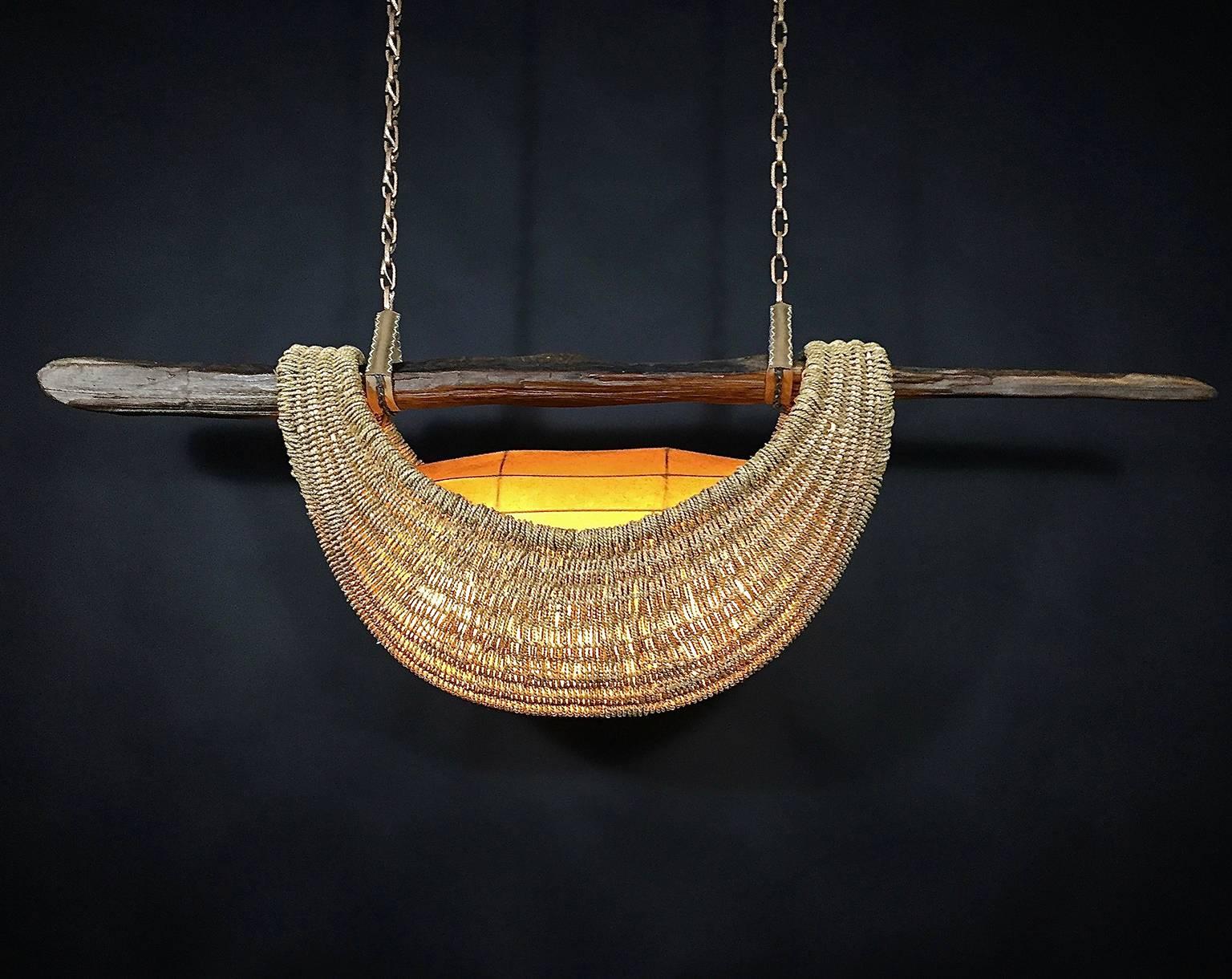 This handmade, custom light sculpture or fixture made with Big Sur driftwood, reed, Oriental sea grass, cast bronze chain, handmade brass chain, leather, rawhide, steel, and UL listed electrical components for use with LED bulbs is by Los Angeles