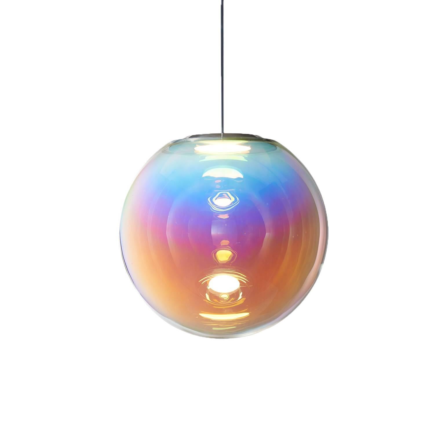 The Iris pendant light appears like a permanent iridescent soap bubble. It is the result of ambitious craftsmanship and technological innovation. An OLED module provides both the light source and mount, with an iridescent film creating the
