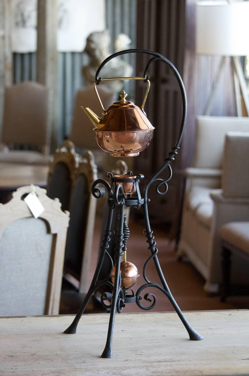 A rare Dr. Christopher Dresser designed copper spirit kettle on wrought iron stand. It was manufactured by Benham & Froud of London and bears their famous 