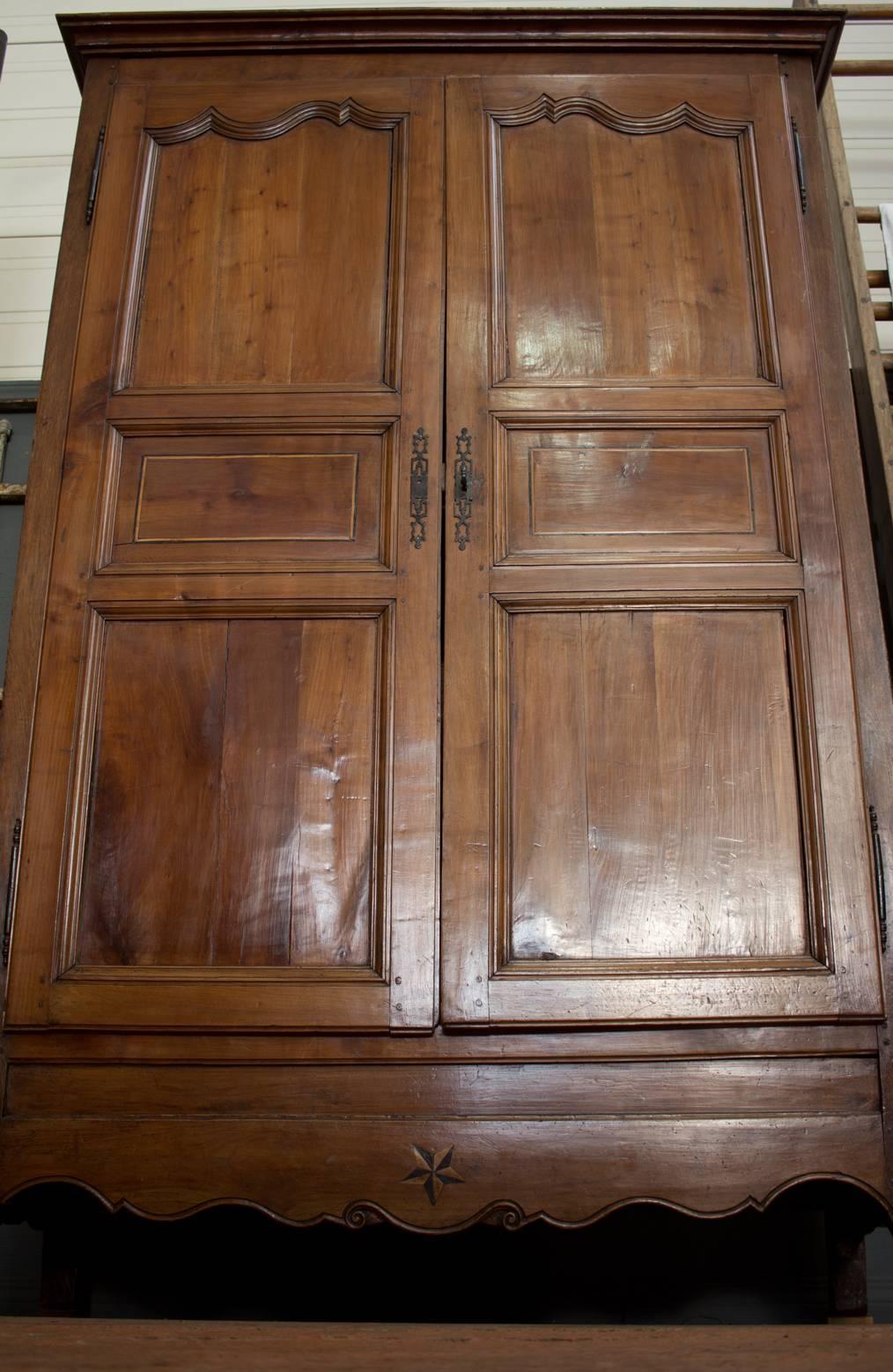 Beautiful antique French walnut armoire on cabriole legs. It has a rare and unusual five pointed star inlay thought to represent good fortune. Beautiful patina.

In more recent times, the interior has been retrofitted with cupboards and drawers.
