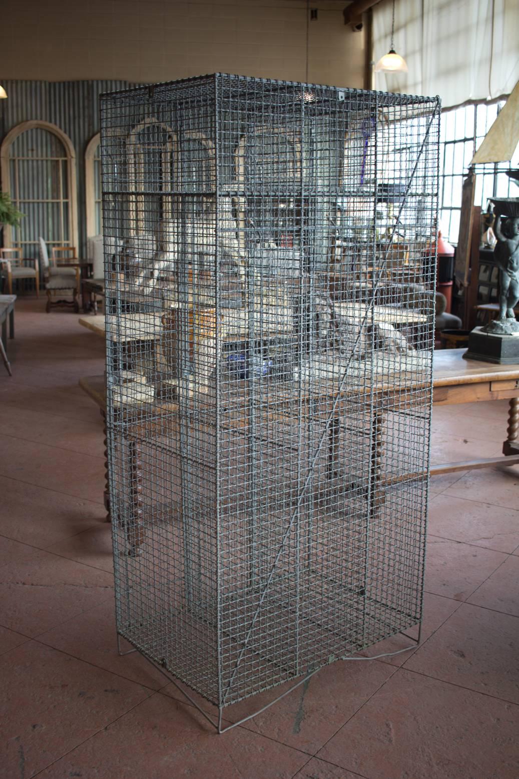 Vintage English triple metal mesh gym locker. It has a shelves to the top and hooks.