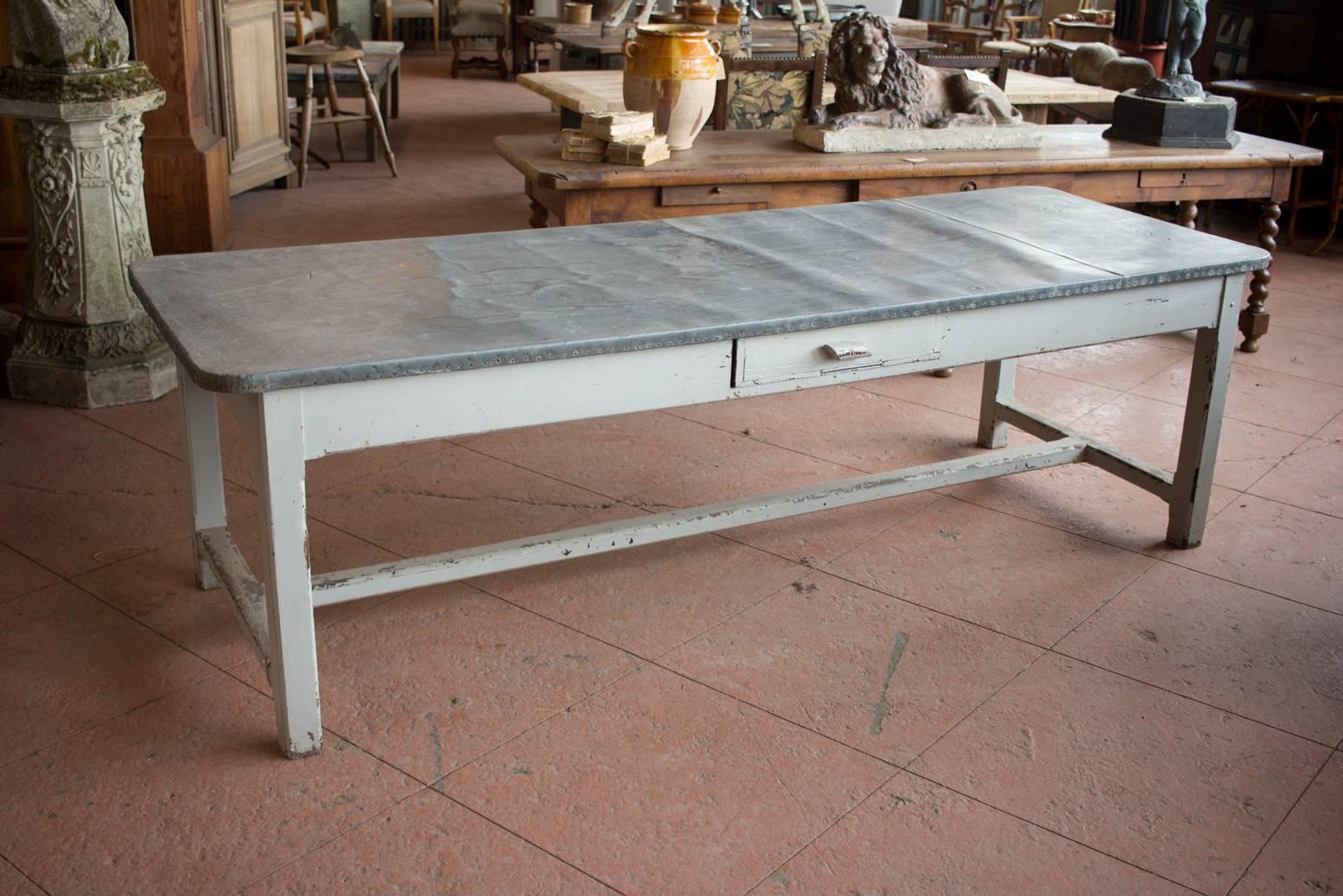 Substantial antique English painted pine zinc top preparation table with three drawers on an H stretcher base.