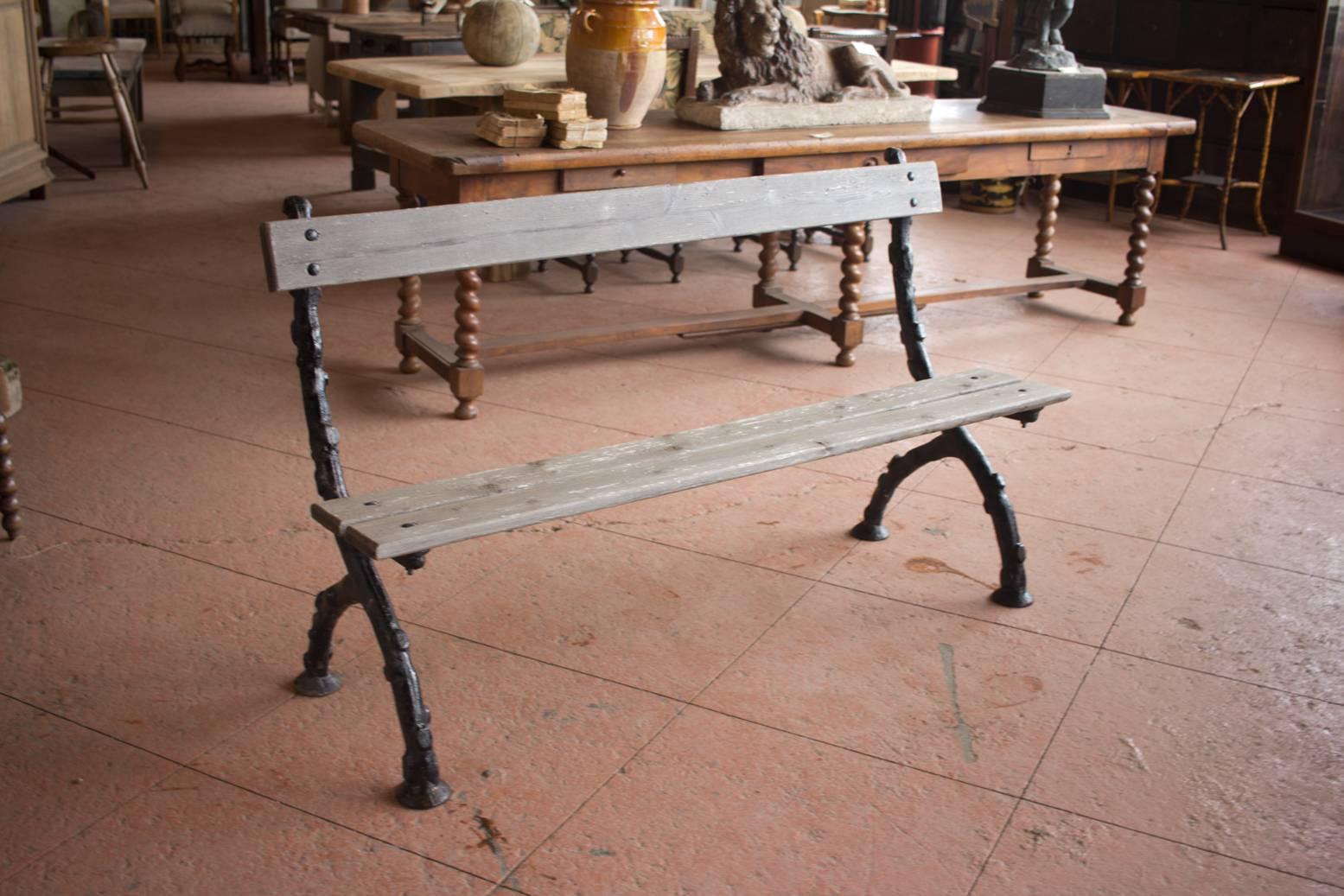 Lovely vintage English faux bois (false wood) cast iron garden bench with wooden slats secured with original iron studs.
