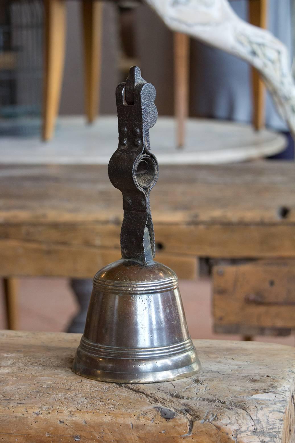 Antique bronze bell with its original clanger. It has a beautiful hammered iron shaft. This would have graced a large door possibly from a chateau. Found in the Languedoc-Roussillon region of Southern France.