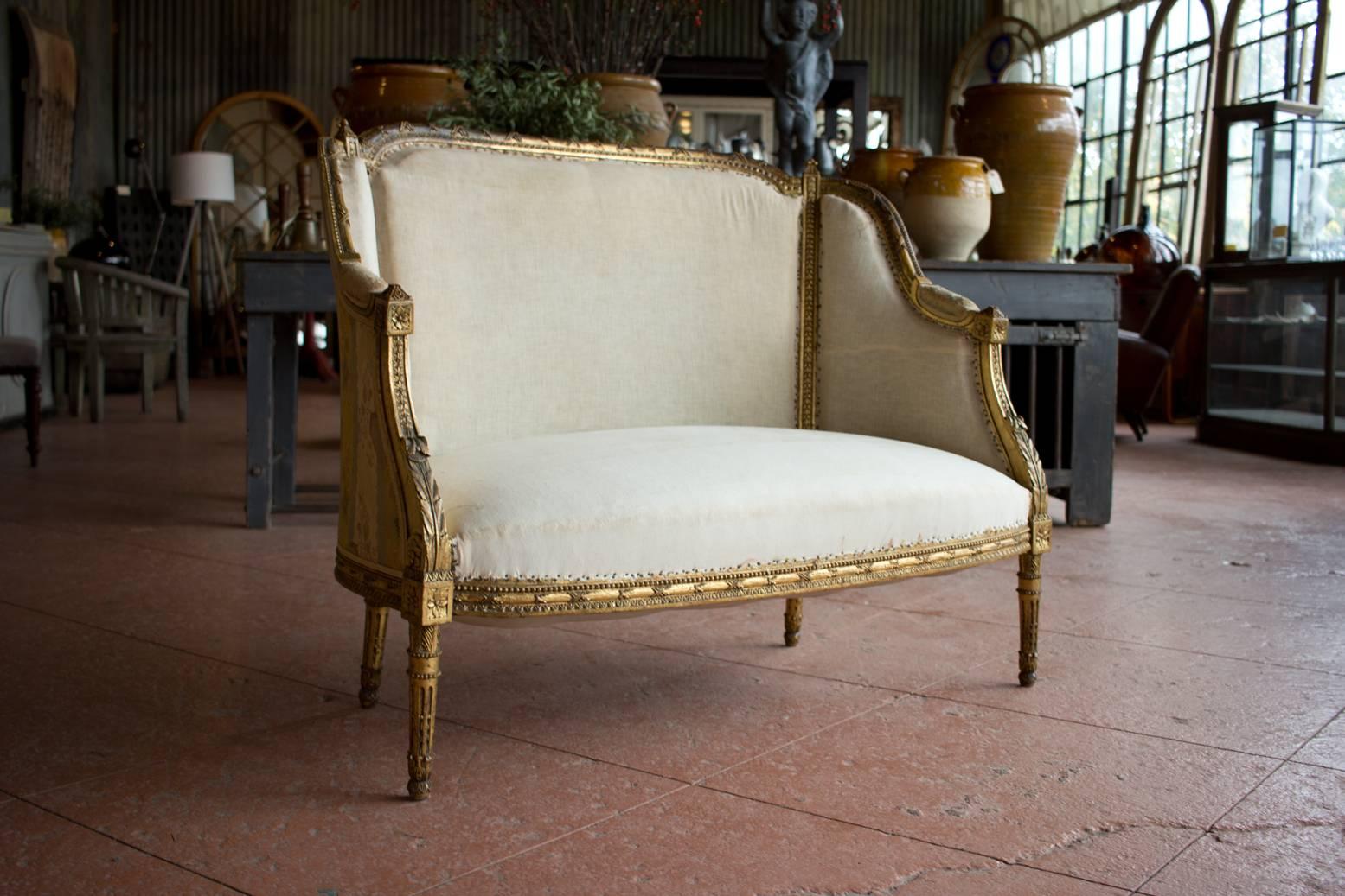 Antique Louis XVI petite bergère settee settee with original gilded frame.