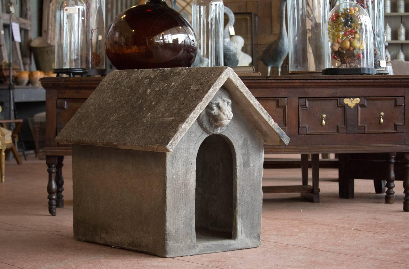 Rare vintage quintessential English composite stone dog house. Beautifully patina'd over the years with a lion's head mask over the doorway.

As you can see, it fits two Dachshunds (Uh-Oh and Buddy) comfortably!