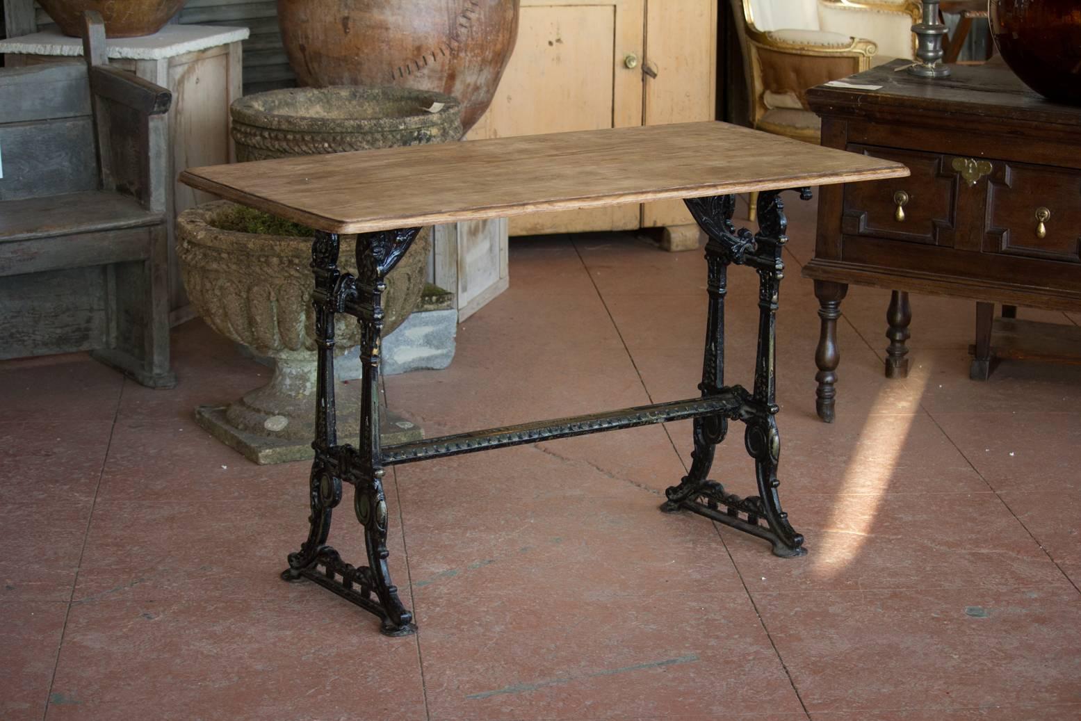 Early 20th century cast iron base pub or garden table with a hardwood top. This table was designed by British makers Lawn & Howarth of Manchester. Beautiful quality base and color.