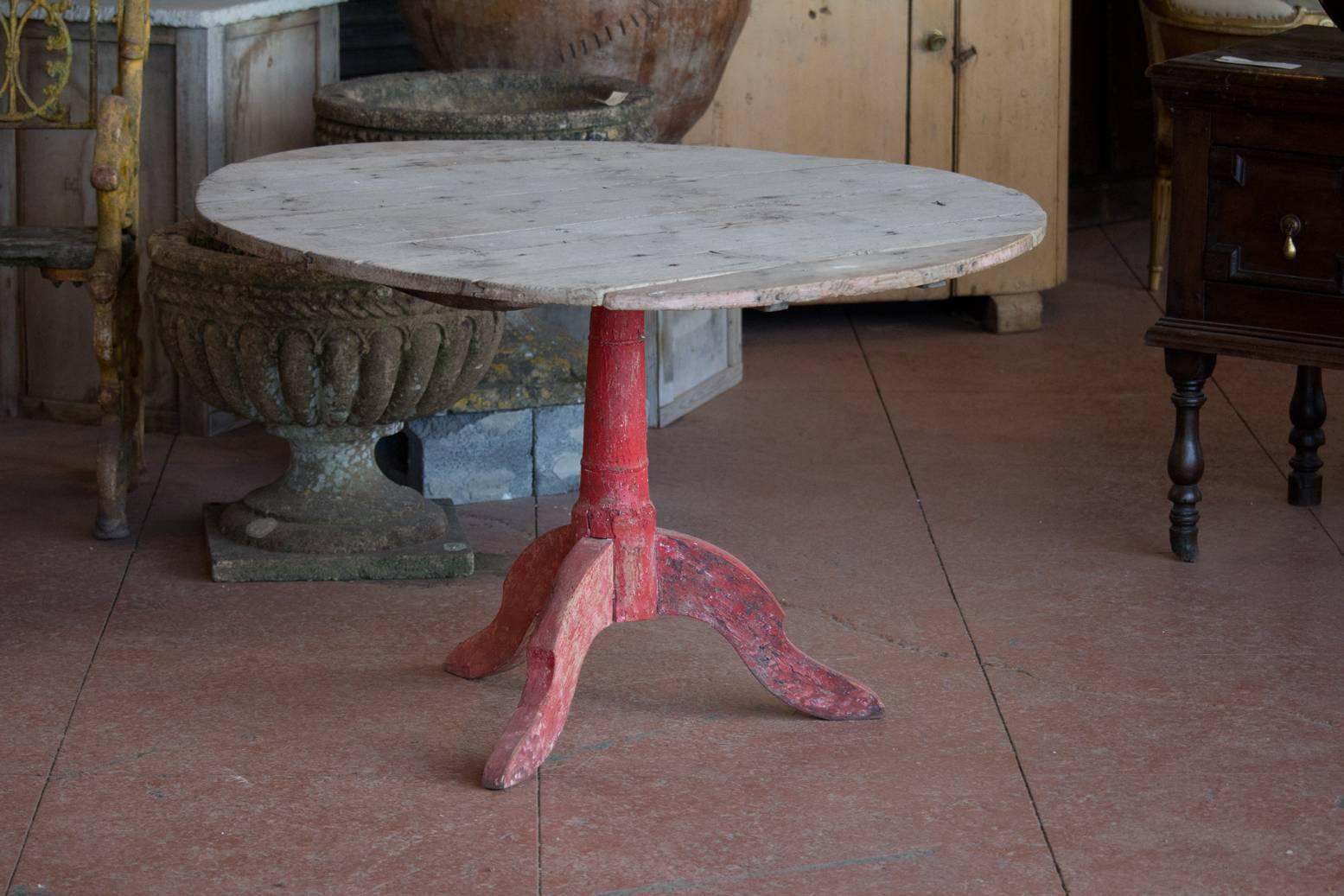 Very unique and rustic antique French farmhouse tripod table with its original red paint. The wood slats can be removed to make a smaller table.