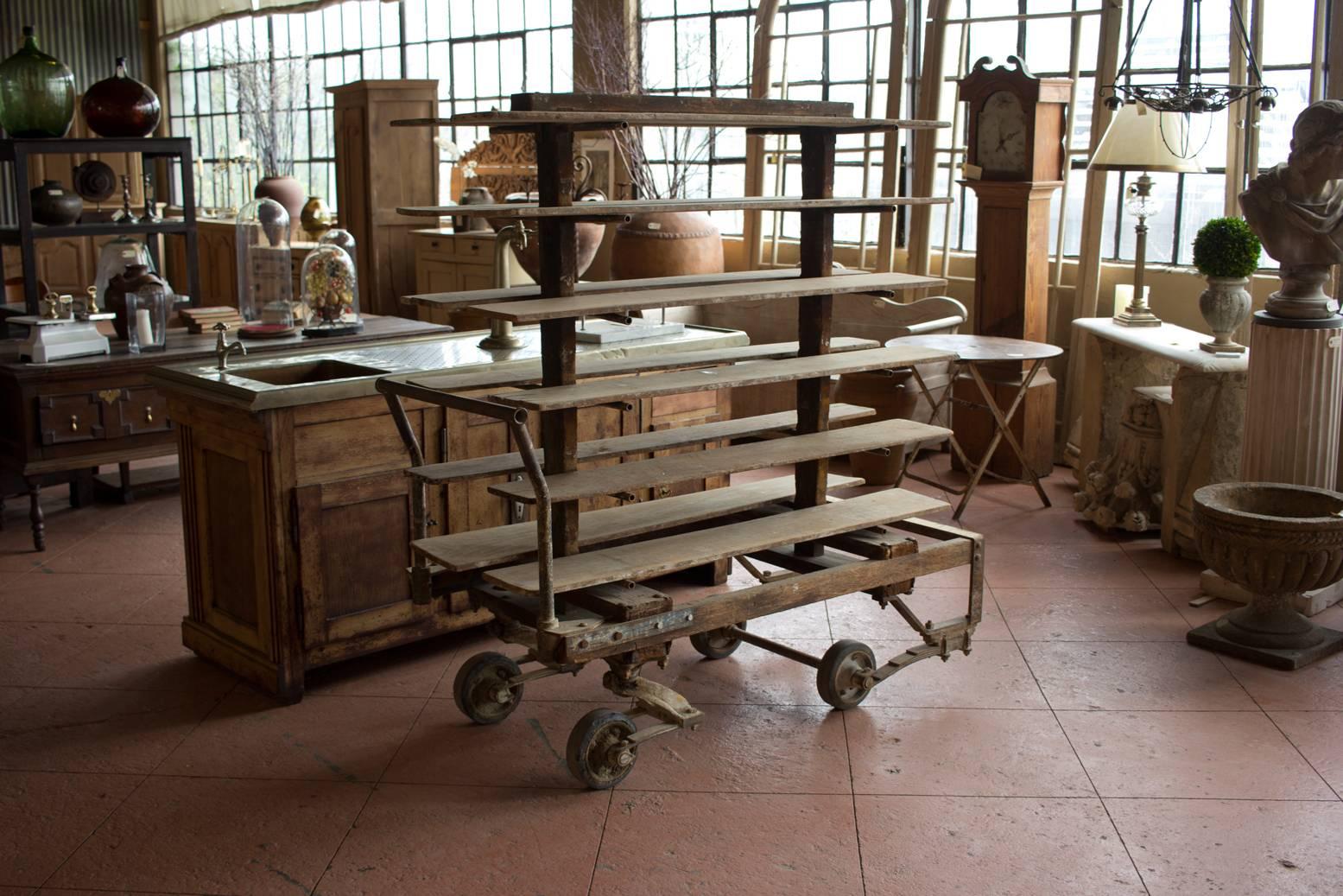 Substantial and rare antique factory cart with 12 shelves. The cart came from the famous Buffalo Pottery Company in New York. They have shock absorbers on them due to the nature of carting around the porcelain chinaware. 

We have two available!