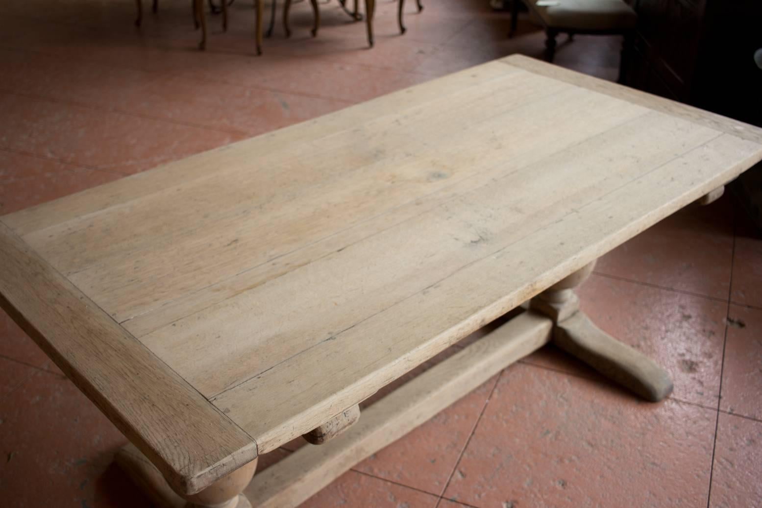 Antique Tudor Revival trestle base, stripped back bleached oak refectory table. It has a plank top with breadboard ends and gorgeous carved bulbous legs.