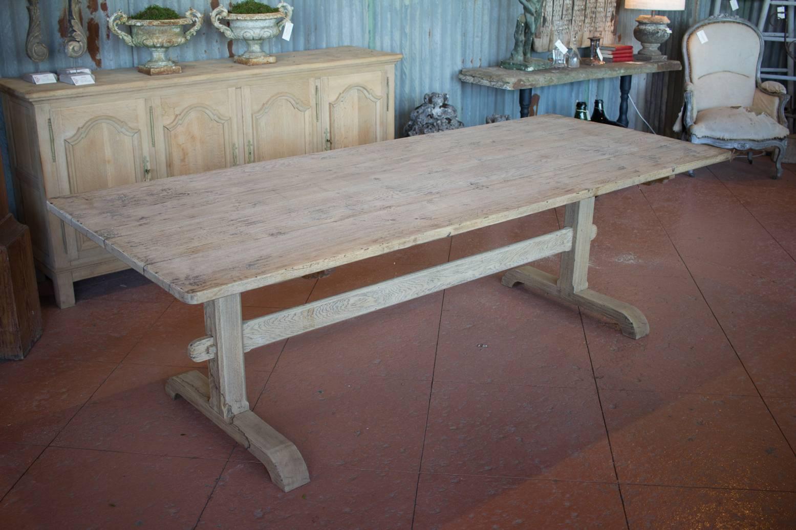 Large antique bleached French elm stripped back trestle table, easily accommodates ten chairs.