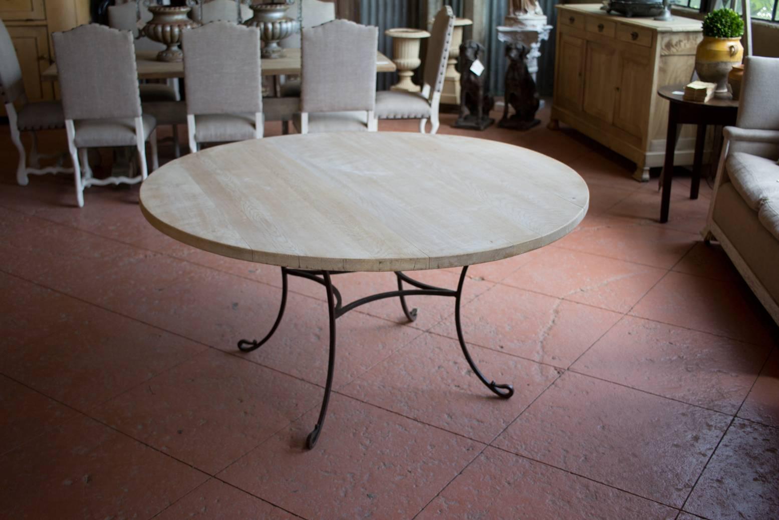 Beautiful quality Spanish hand forged wrought iron table base with large round bleached oak table top. Seats six nicely.