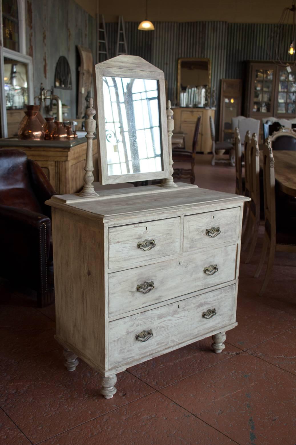 Antique petite French country pine chest of drawers with its original distressed mirror and original brass drawer pulls on beautiful turned feet. It has a lovely newer paint finish. Could be retrofitted with a small sink for a powder
