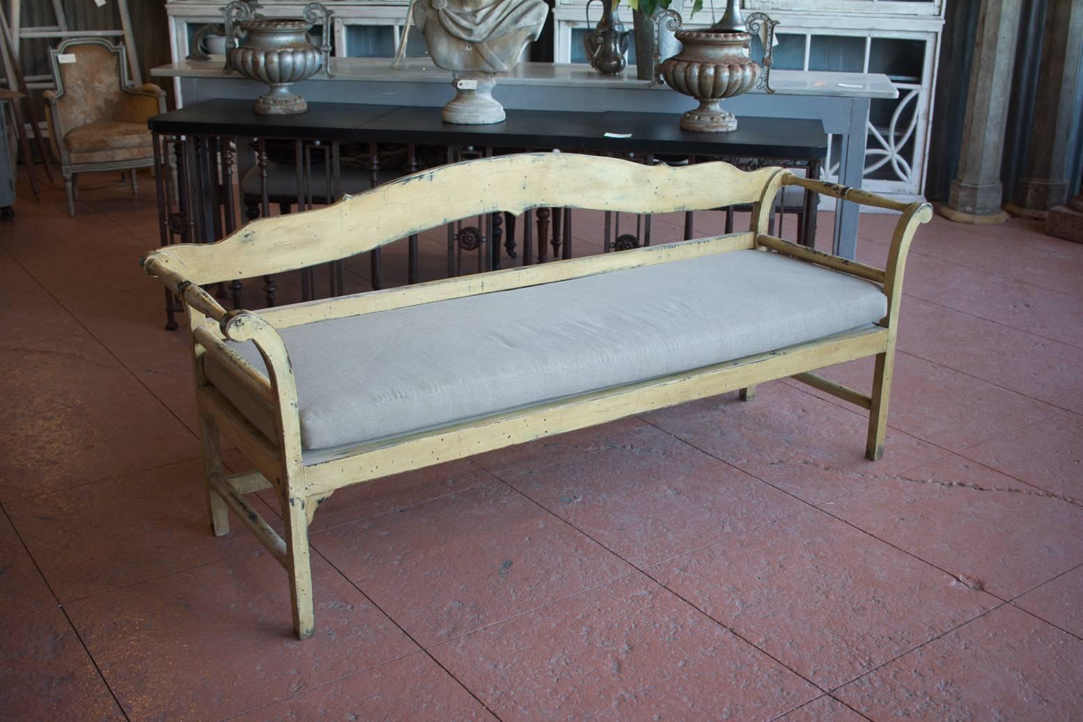 Vintage Gustavian style painted bench with upholstered cushion. Shaped back with turned scrolled armrests. Wonderful quality mortice and tenon construction.