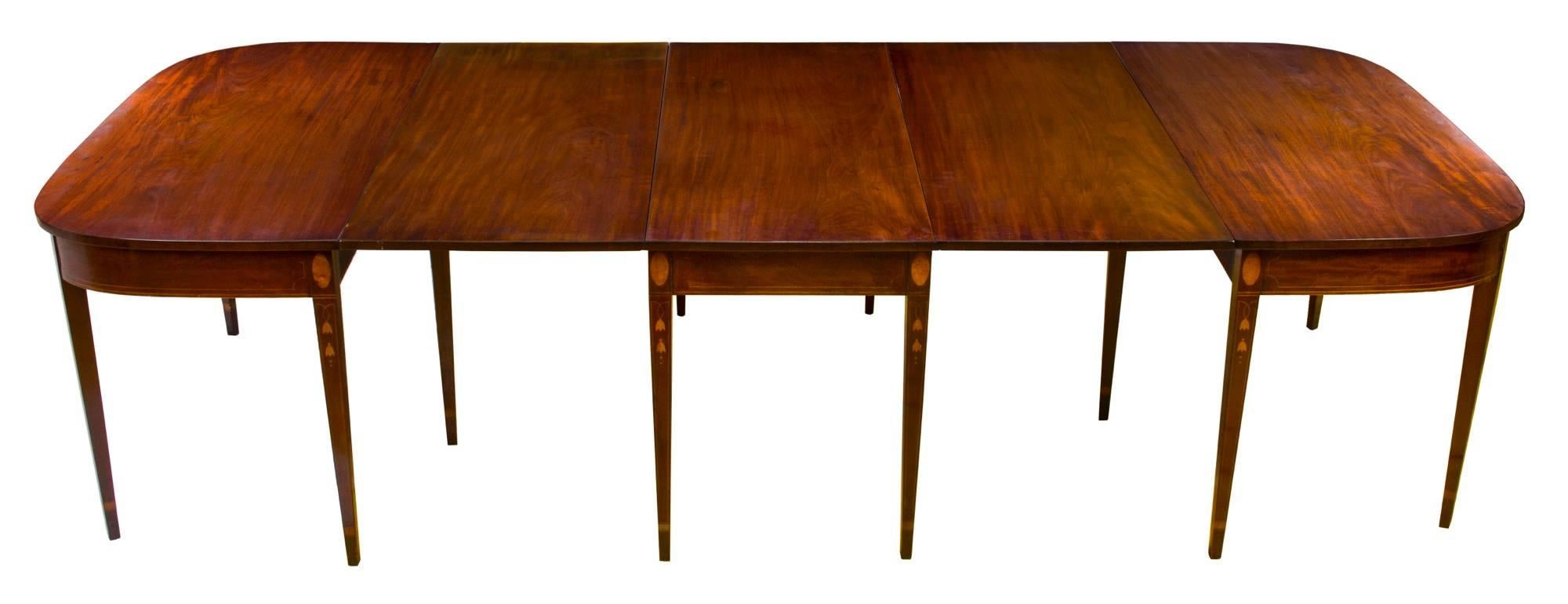 This banquet table is a celebration of magnificent solid strikingly vibrant and ribboned mahogany wood, all supported on strongly tapered legs with traditional bellflower and satinwood inlaid ovals (see close-ups). As you will note, the work is